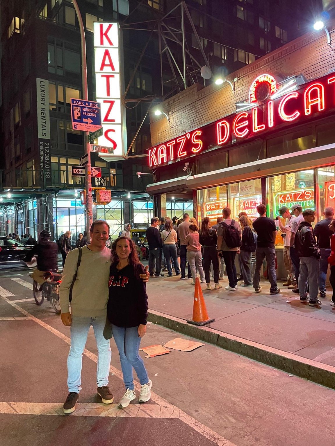 Fachada de Katz's Delicatessen iluminada de noche con neones rojos