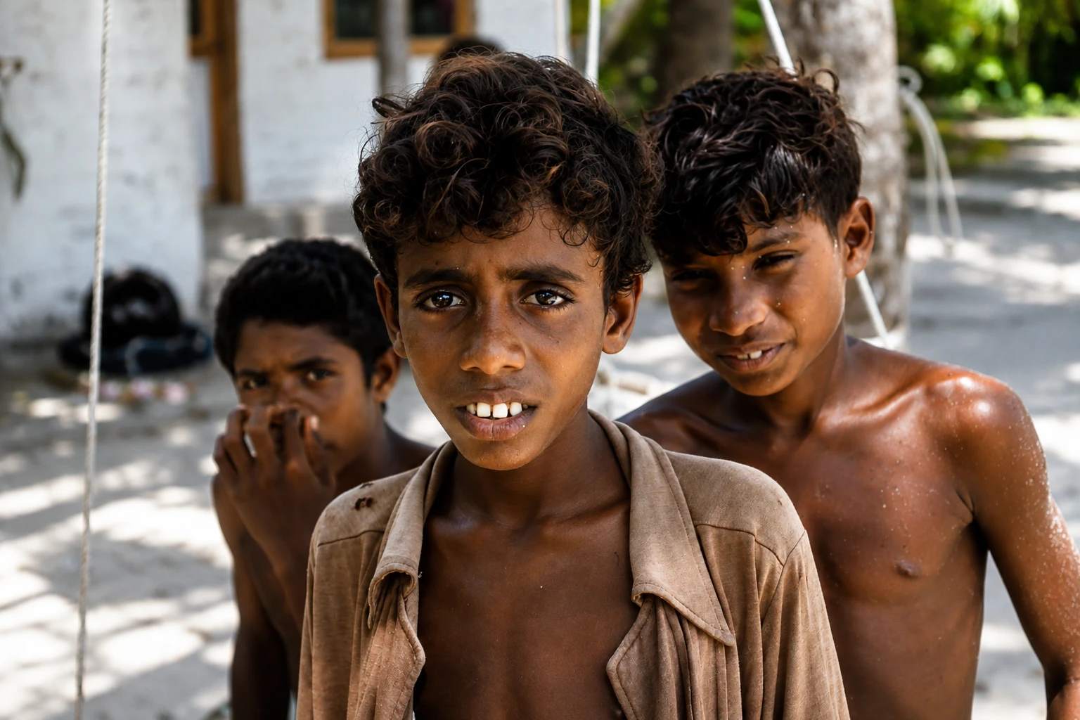 A close portrait of three boys standing together outdoors