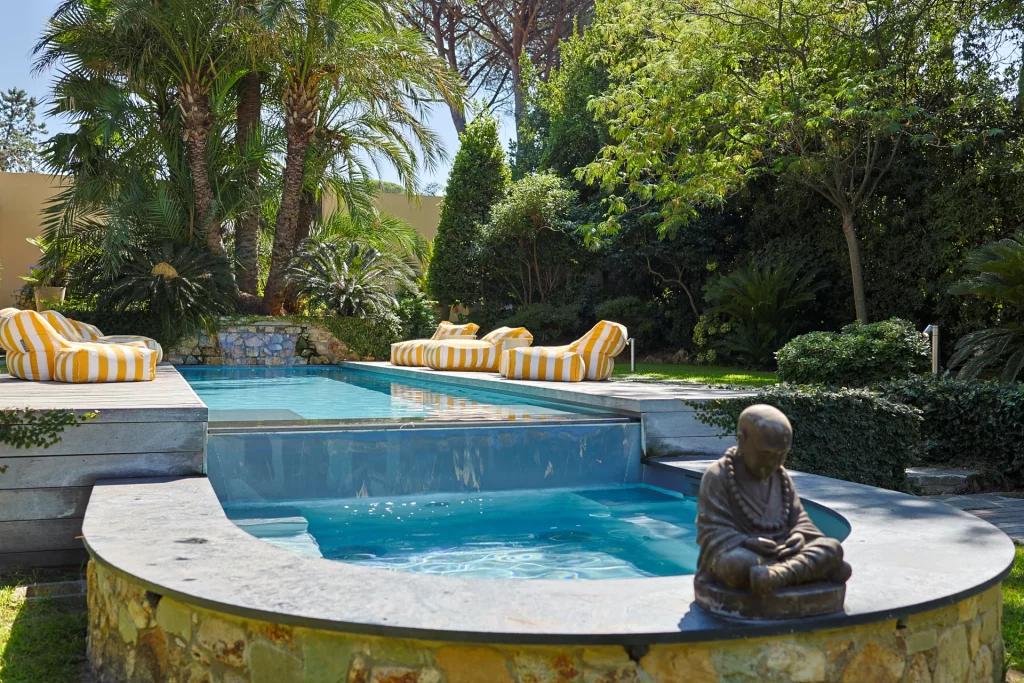 Saint-Barthelemy accommodation - La Tortue - Discover this private pool surrounded by lush tropical gardens with comfortable lounge chairs and a decorative statue.