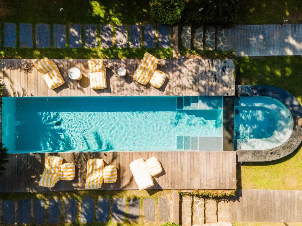 Saint-Barthelemy accommodation - La Tortue - This image shows a modern pool with a wooden terrace surrounded by lounge chairs and umbrellas. The space is perfect for relaxation and outdoor activities.