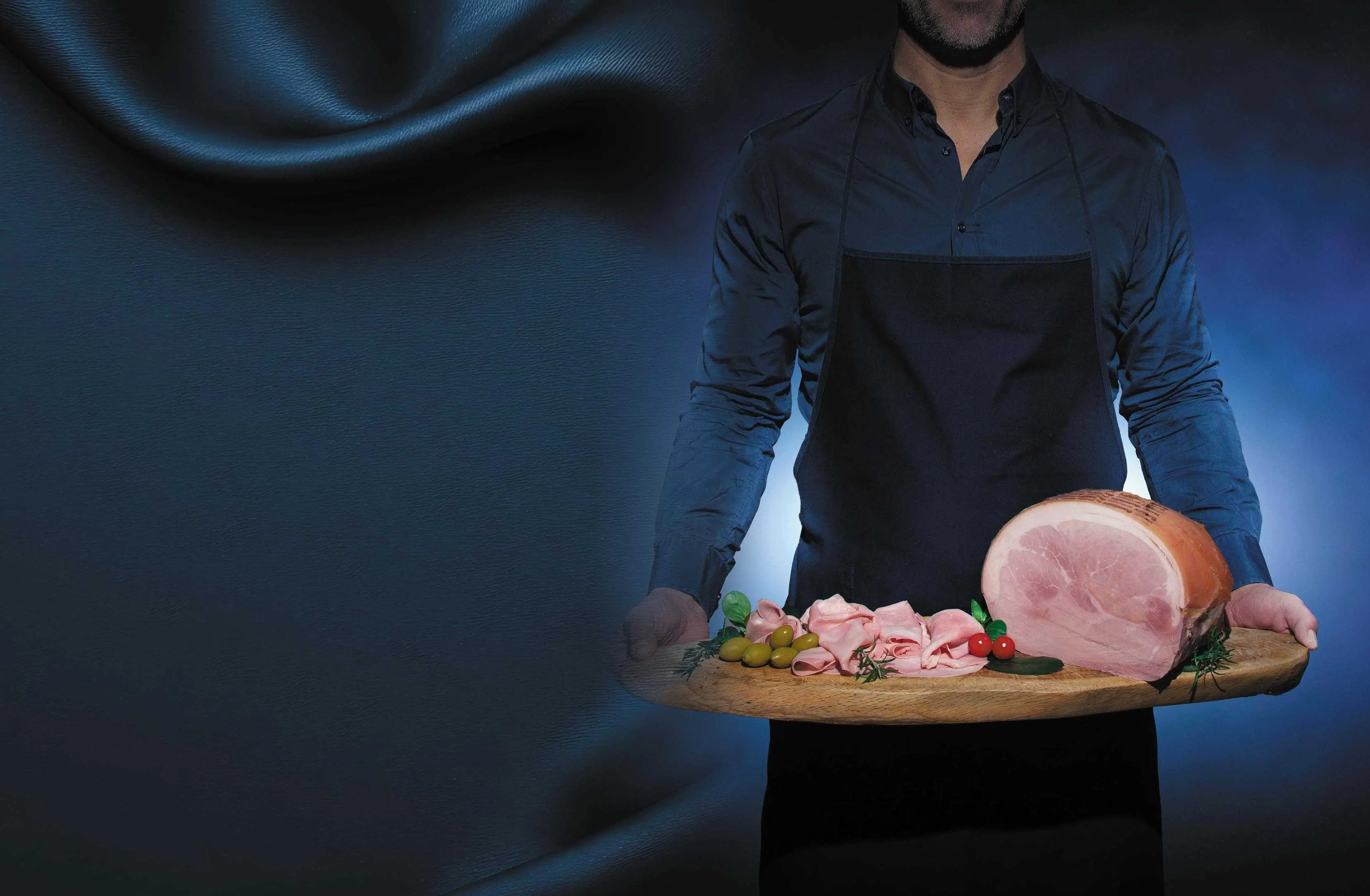 Half-body person holding a cutting board with cooked ham on a blue background