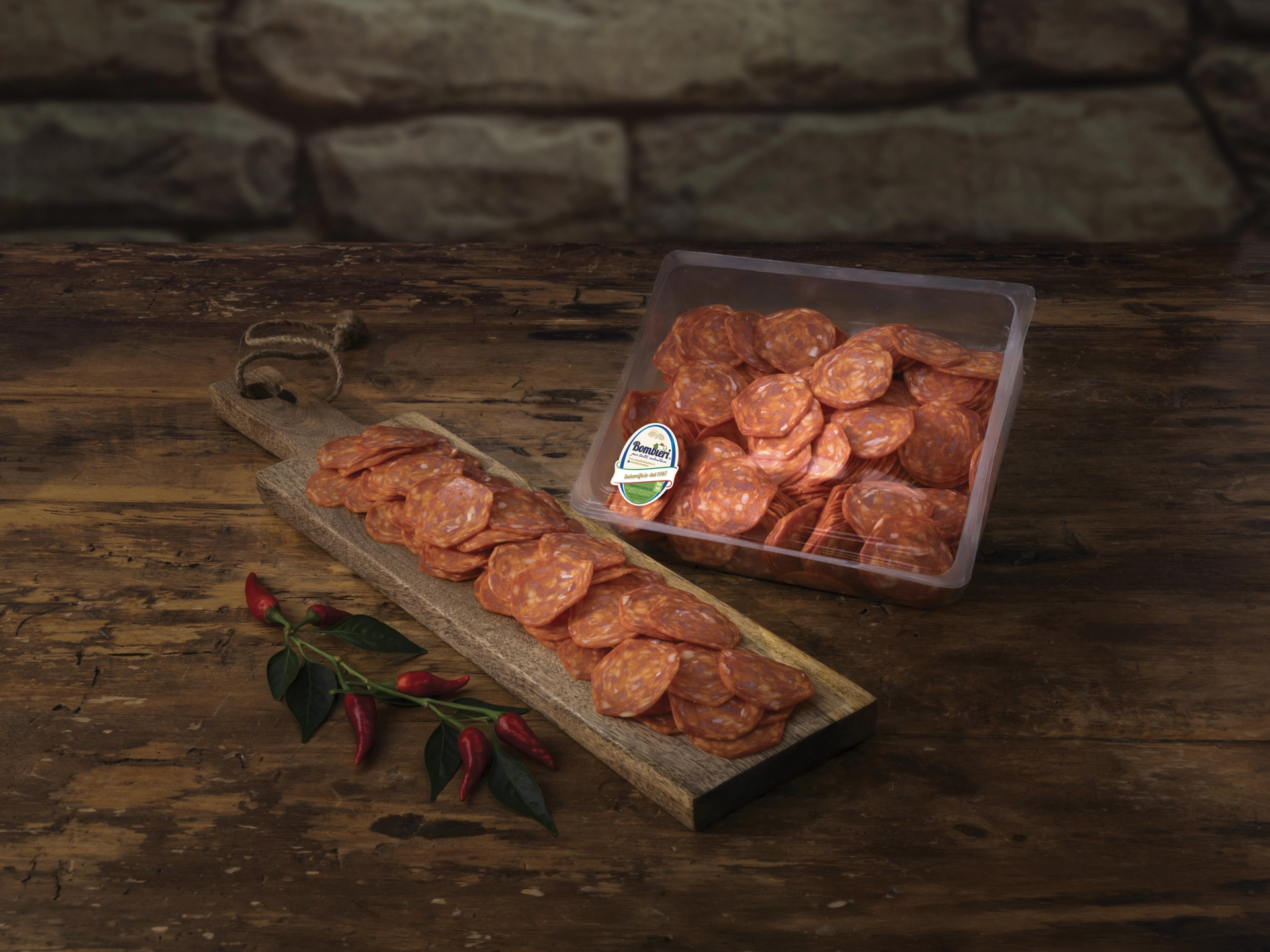 Vaschetta di affettati Bombieri e fette di salame su tagliere di legno