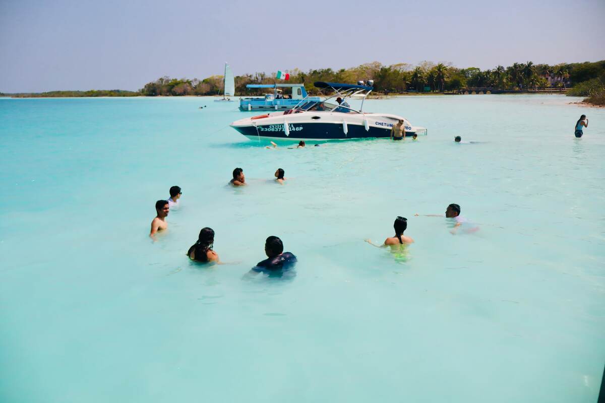 Tourists swimming in the crystal clear shallow waters of Bacalar
