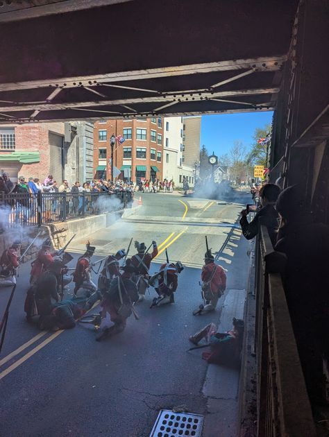 Continental soldiers exchange fire with British forces in front of downtown storefronts