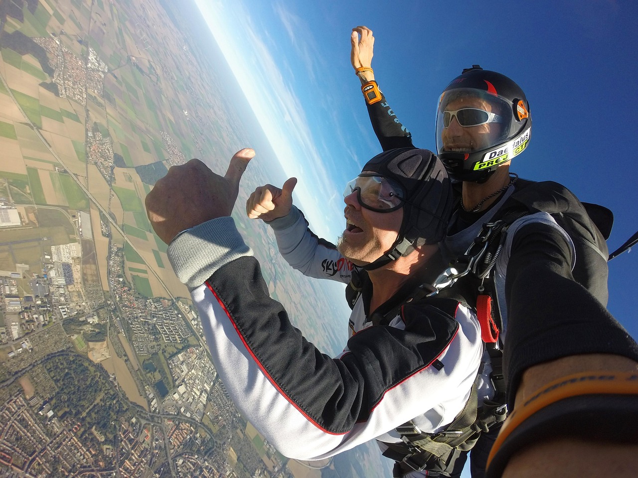 A person skydiving with a parachute open against a blue sky
