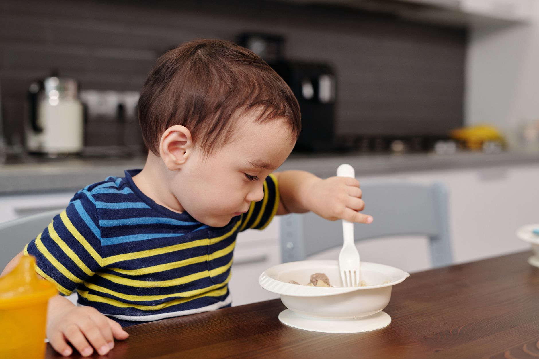 Baby practicing self‑feeding with soft cheese sticks