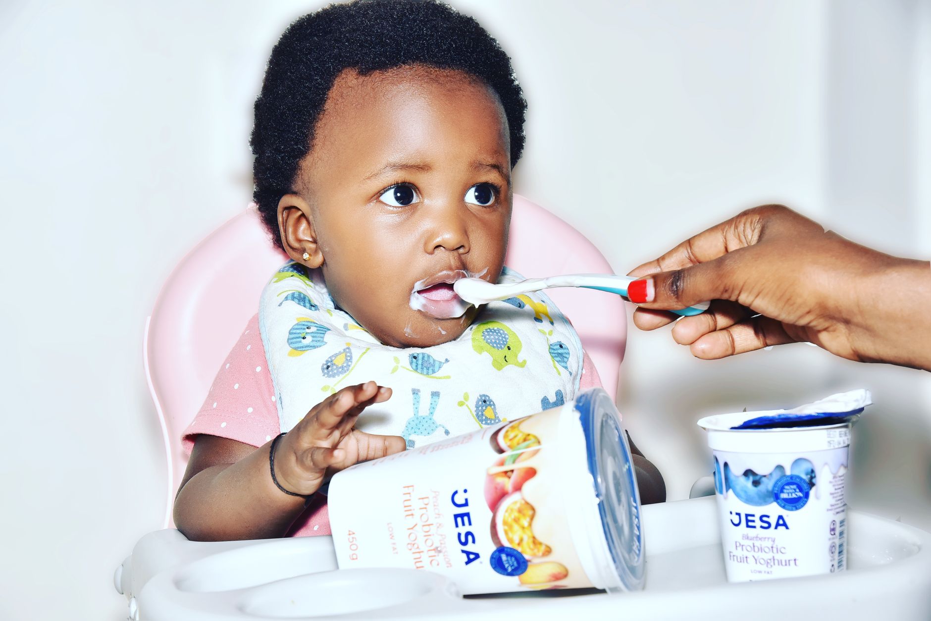 21‑month‑old child holding a spoon and feeding themselves