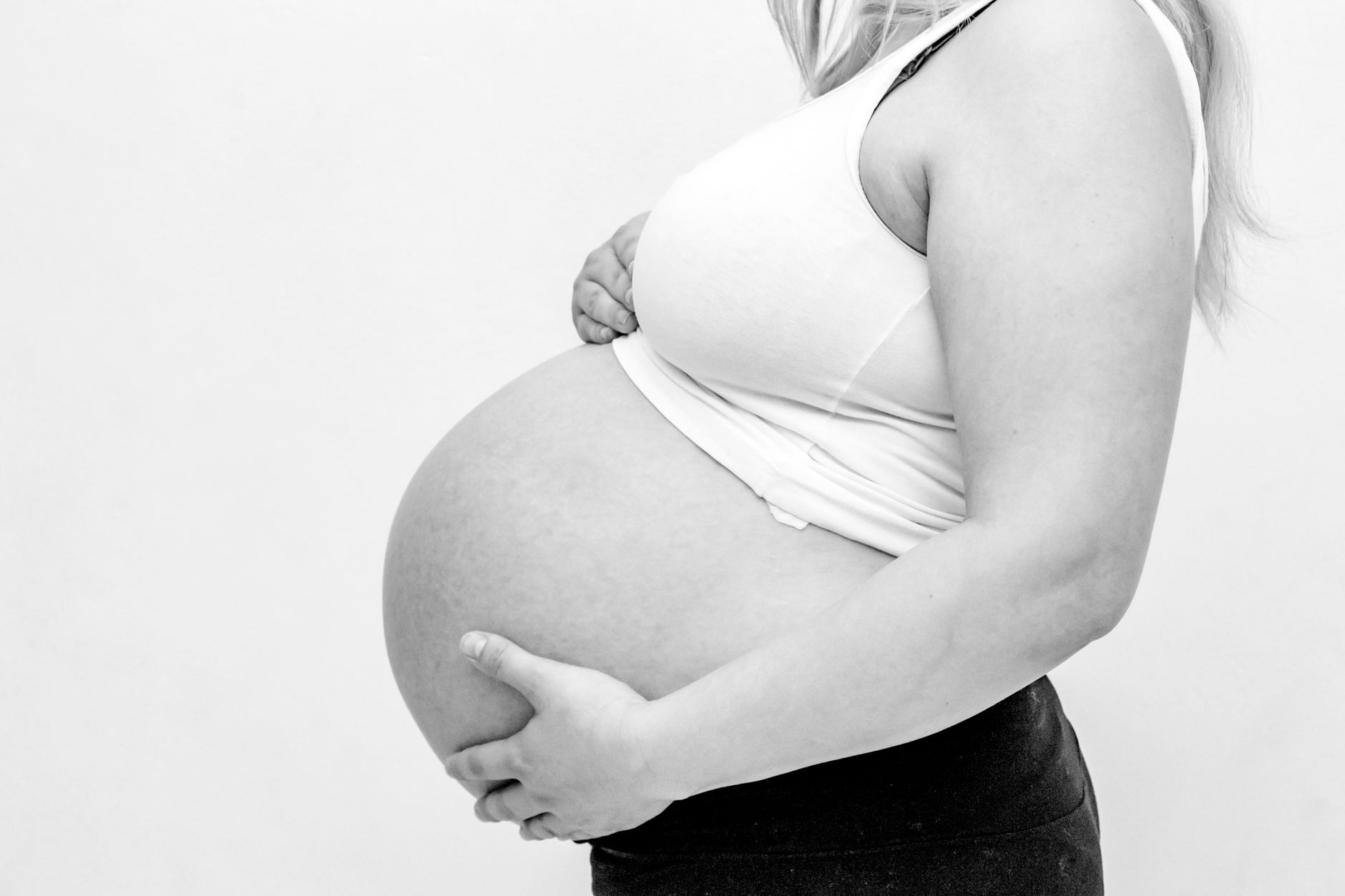 Side-by-side comparison of belly sizes at 22, 24, 26, and 28 weeks pregnant, soft lighting, neutral background