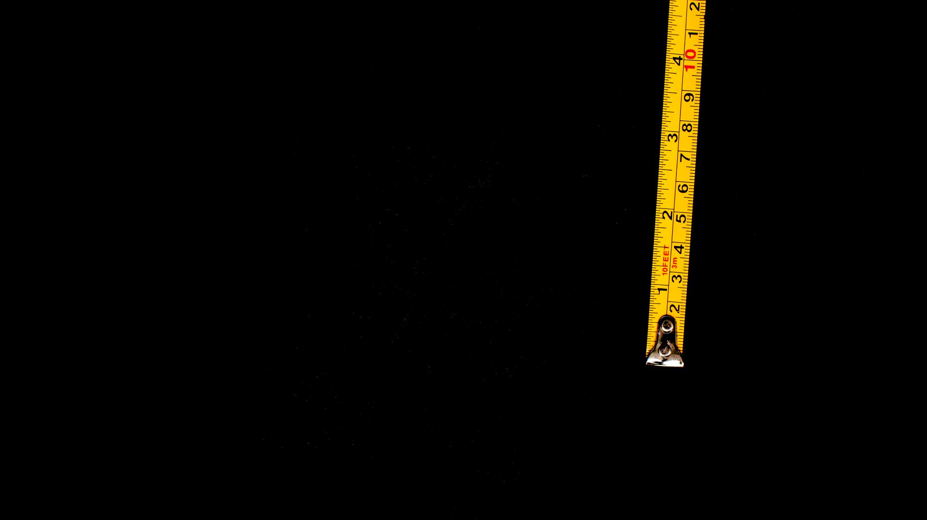 A soft measuring tape stretched out to 14.4 inches next to a head of cauliflower