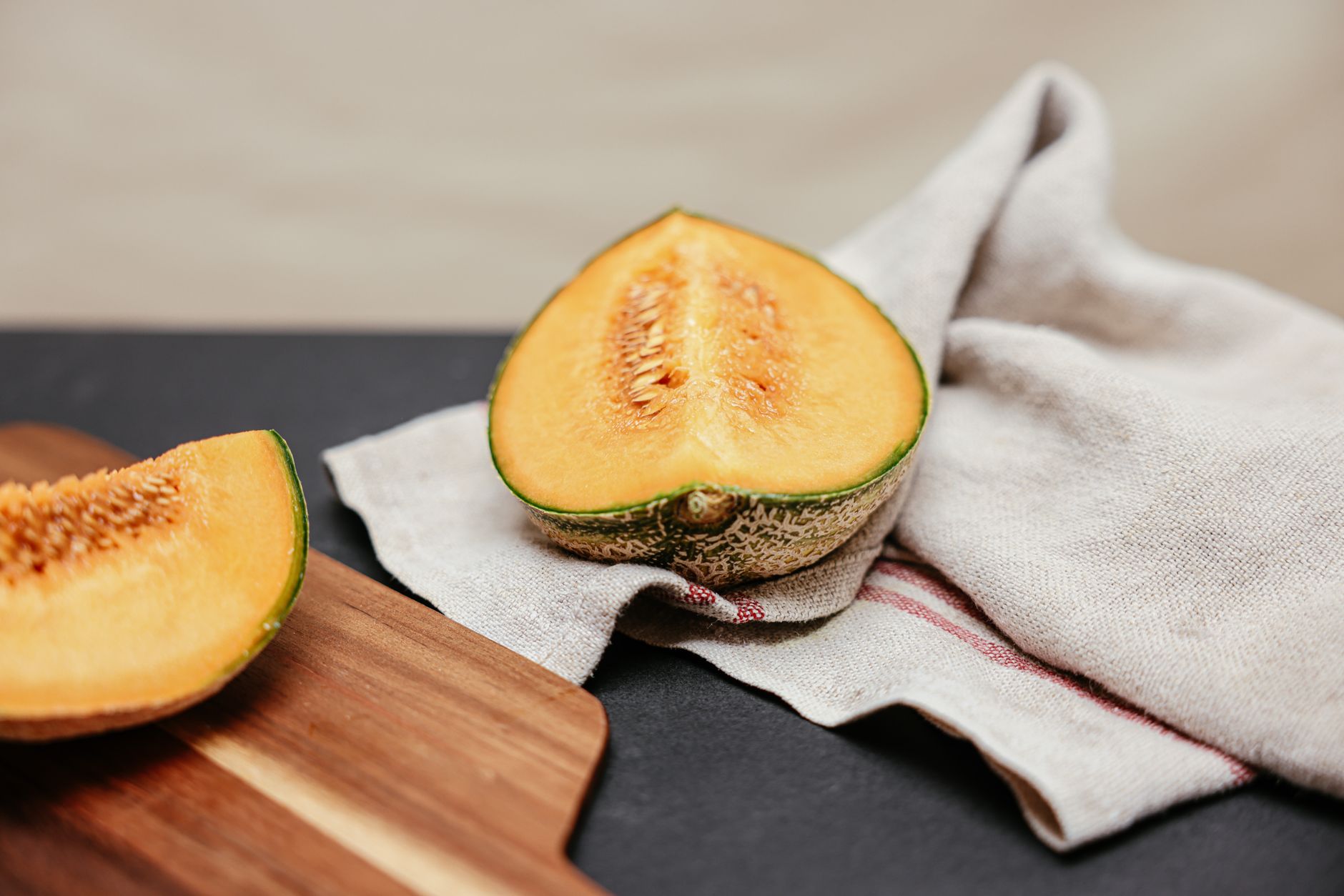A close-up of a ripe cantaloupe sliced open, showing its orange flesh, used to illustrate a 28-week baby size