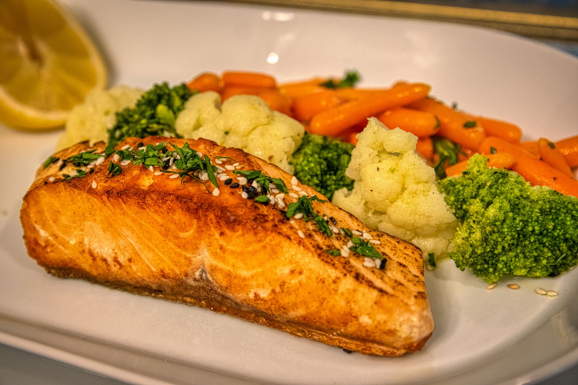 A colorful plate with grilled salmon, quinoa, roasted vegetables, and a glass of water, illustrating a balanced third‑trimester meal