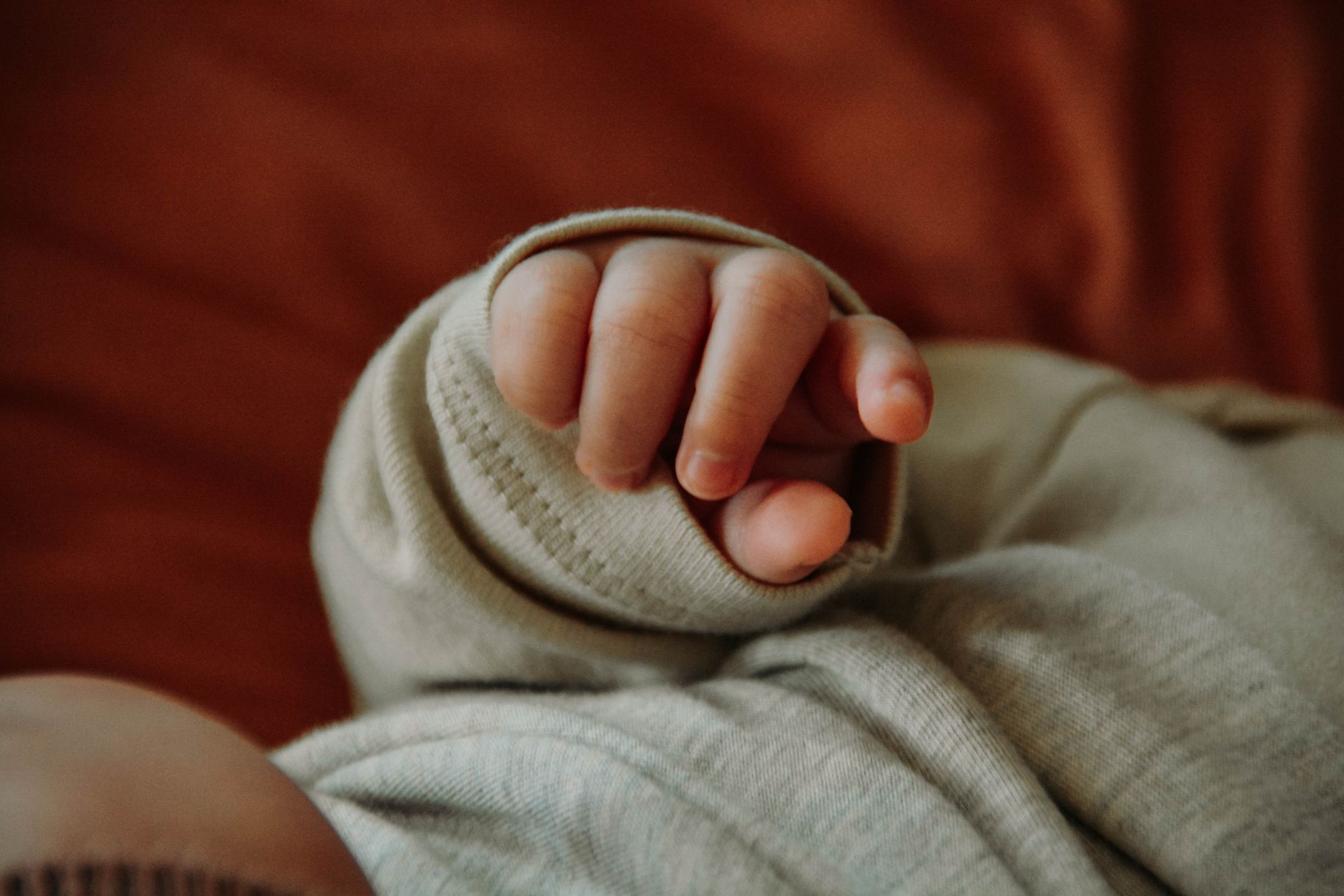 A parent gently soothing a baby in a dimly lit nursery, illustrating a gentle approach to managing sleep associations