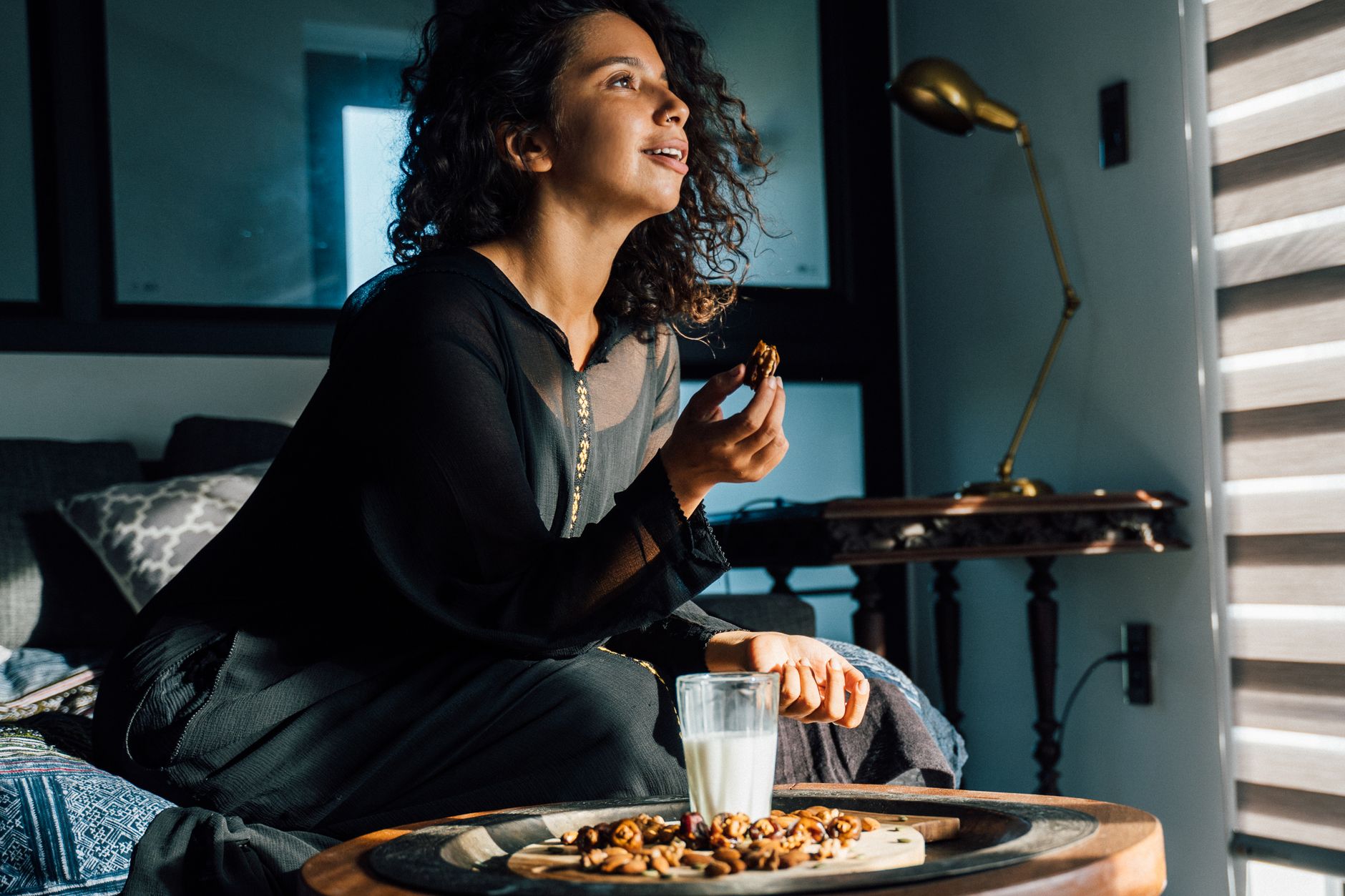 A pregnant woman enjoying a healthy snack, such as fruit or nuts