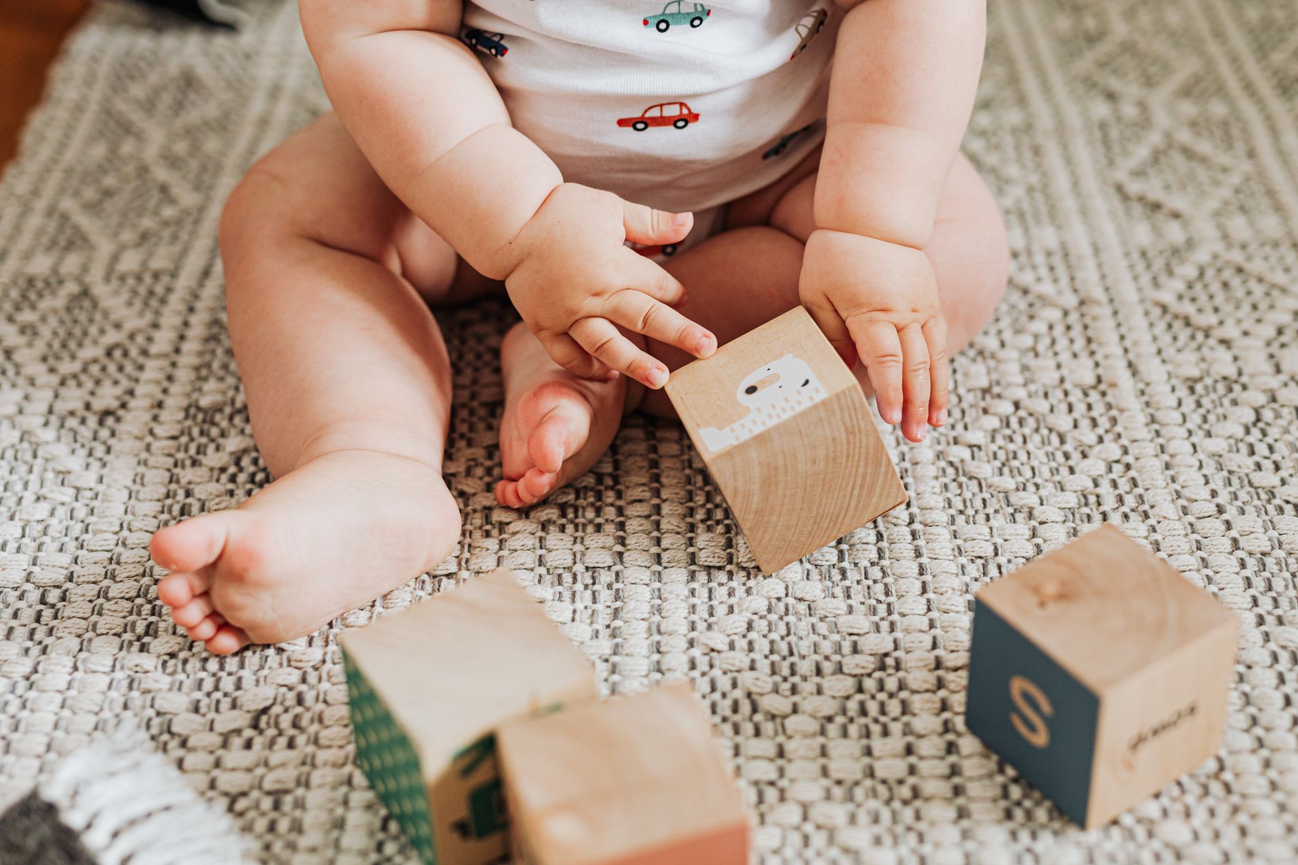 Baby practicing motor skills on a play mat