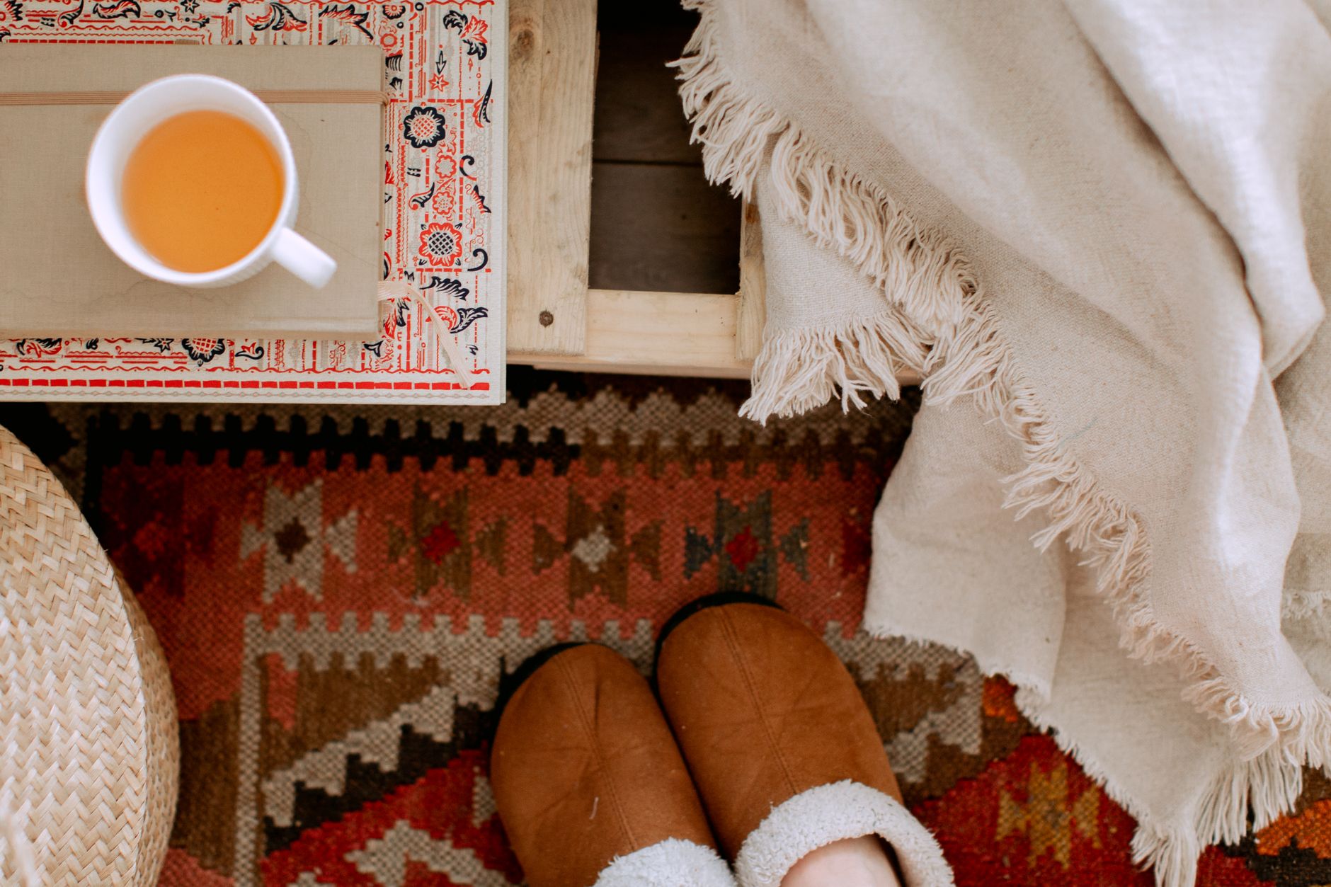 A cozy bedroom scene with a pregnant woman sipping tea, a soft blanket draped over a nightstand, and a small notebook open to a pregnancy tracking page