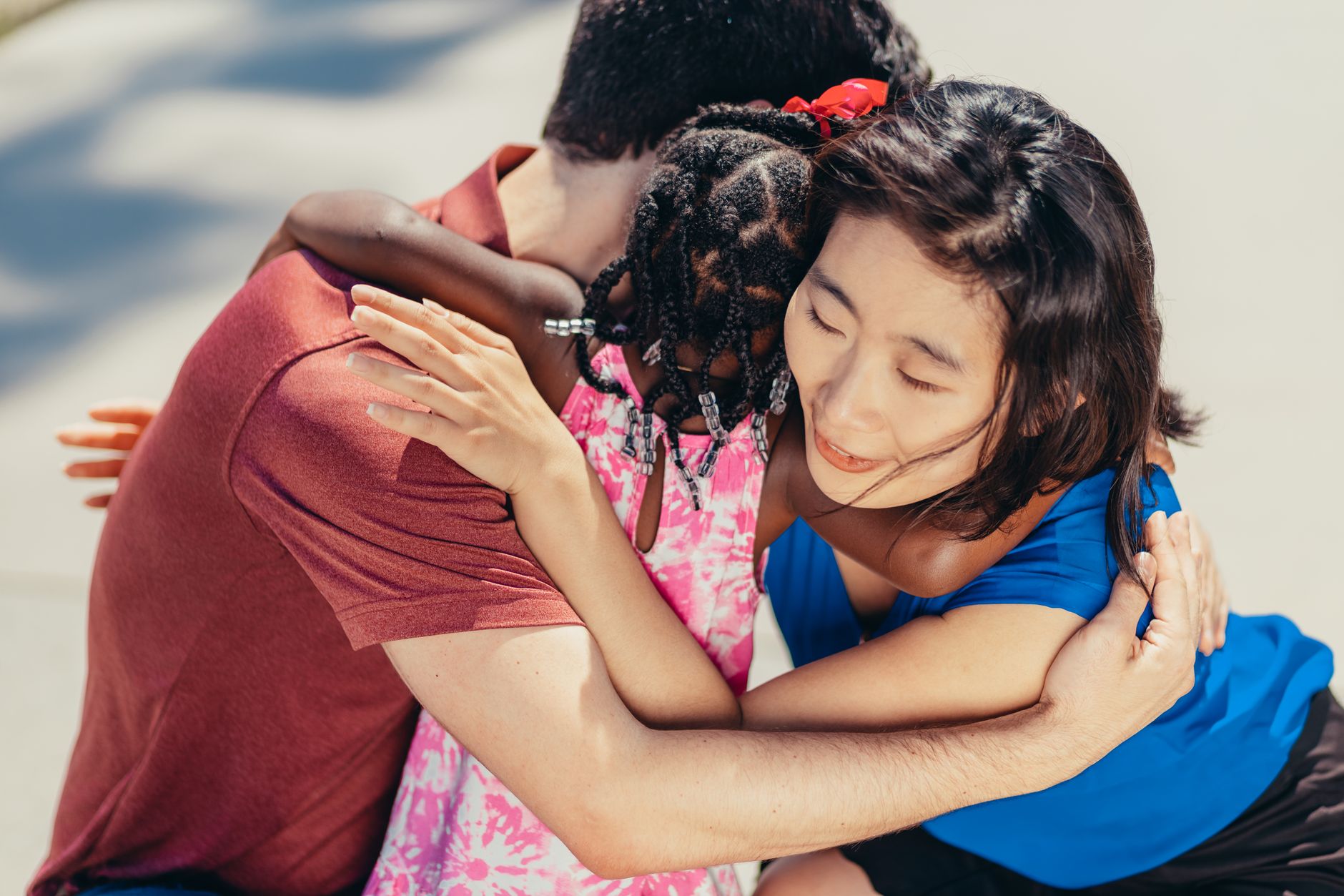 A diverse family of four hugging, symbolizing the love and stability that adoption creates.