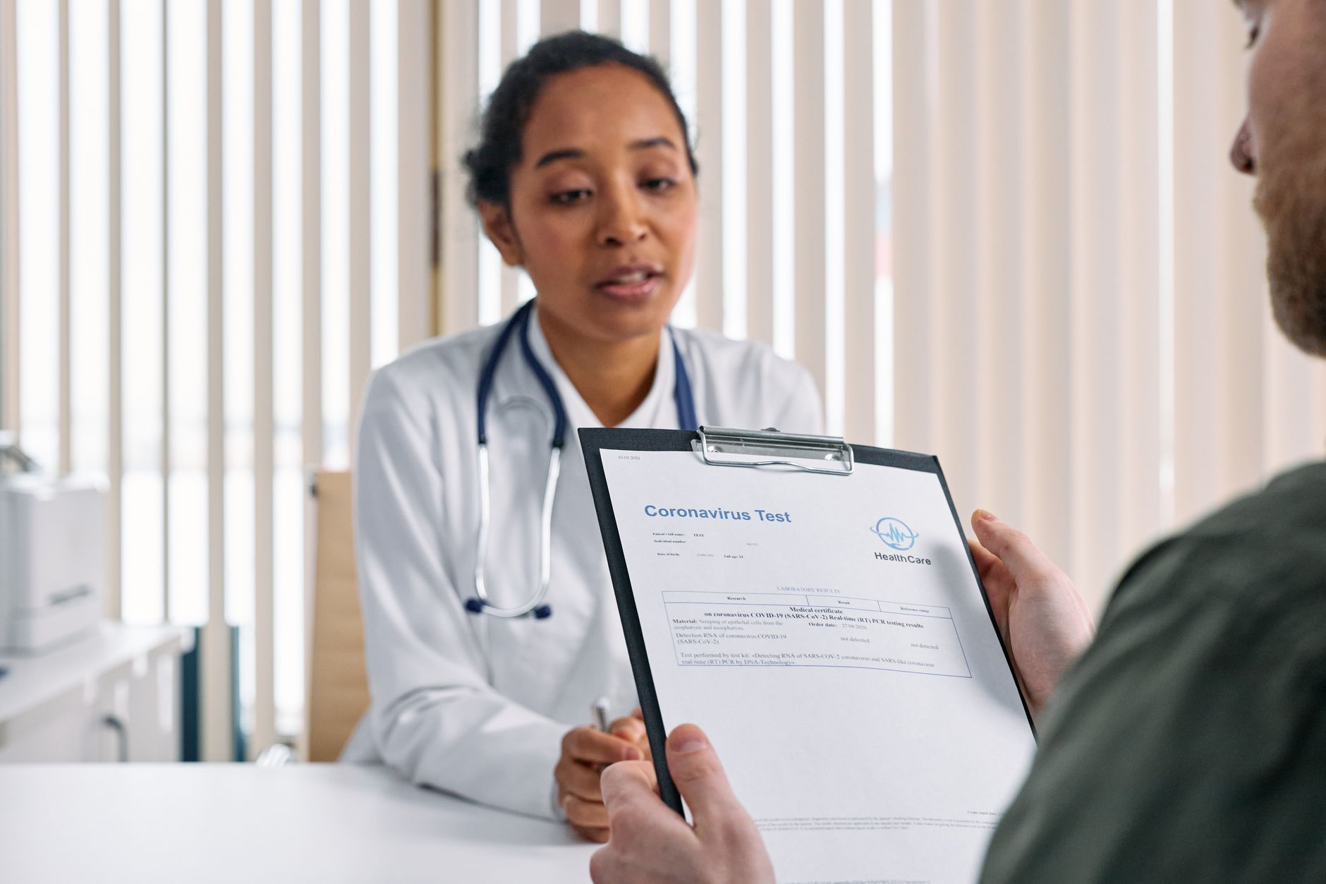 Woman reviewing hormone test results with a doctor in a clinic setting
