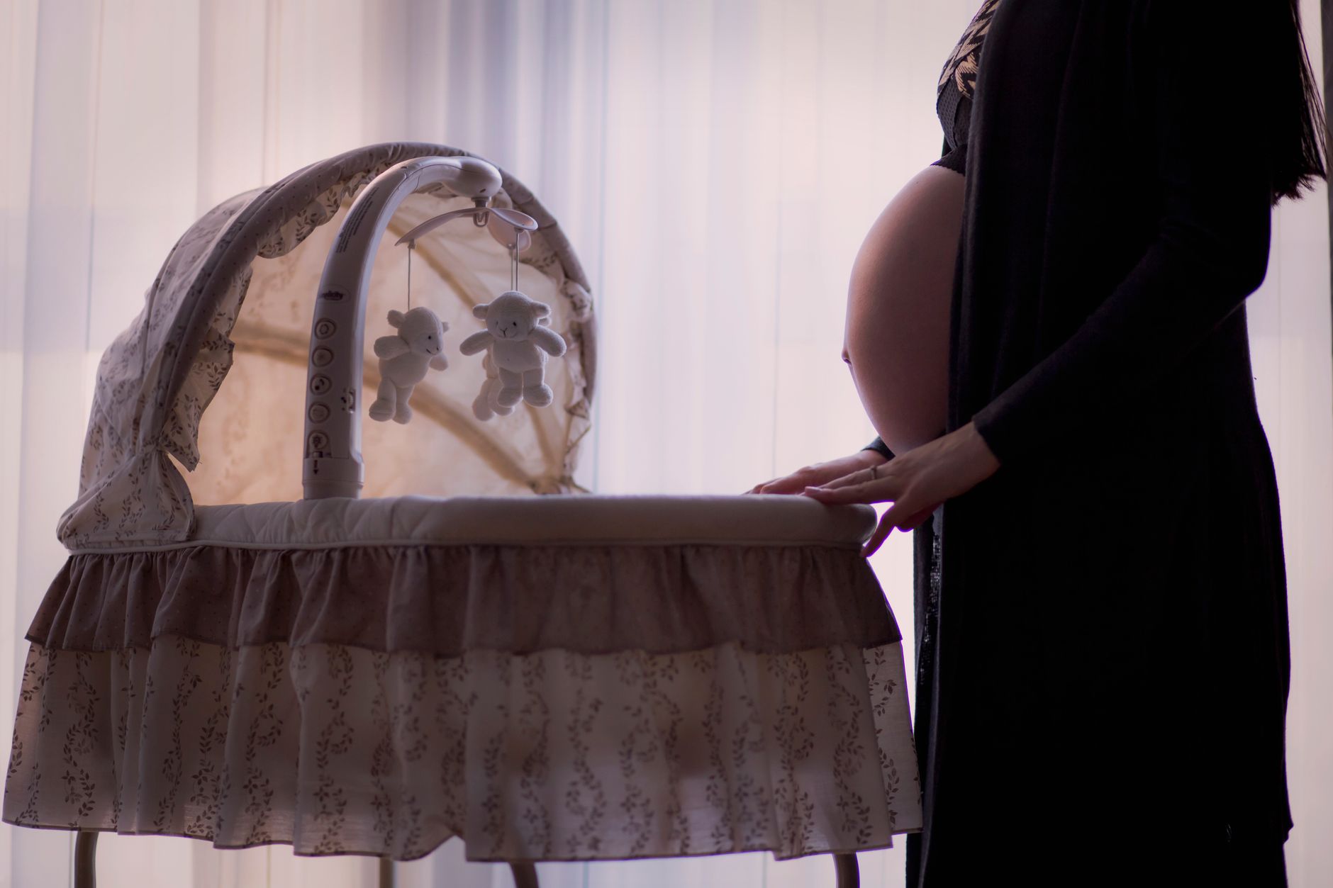 A mother gently holding her two‑month‑old baby close, both smiling, soft natural light from a nearby window