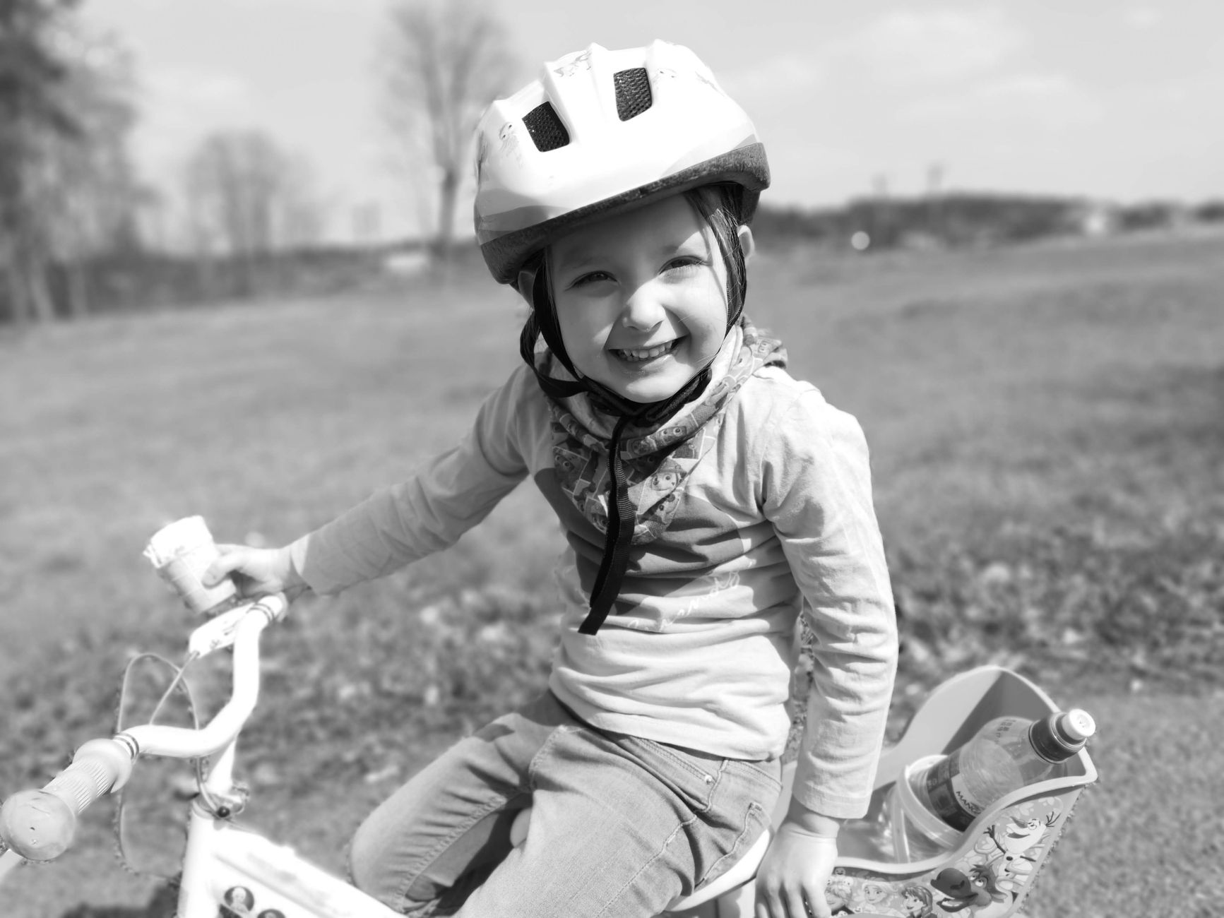 Kindergartener wearing a helmet while riding a bike on a sidewalk