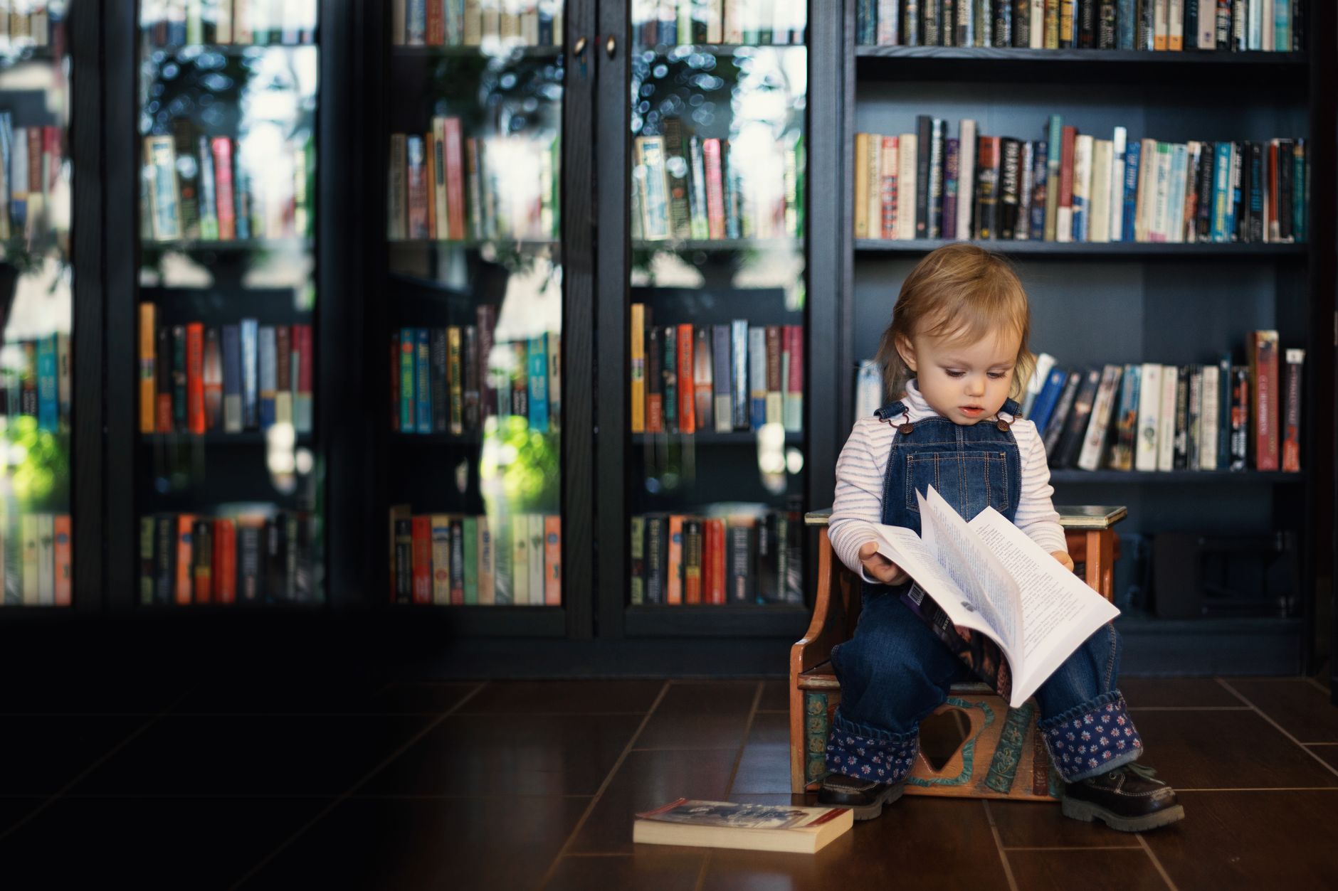 Toddler climbing on a secured bookshelf with anti-tip straps