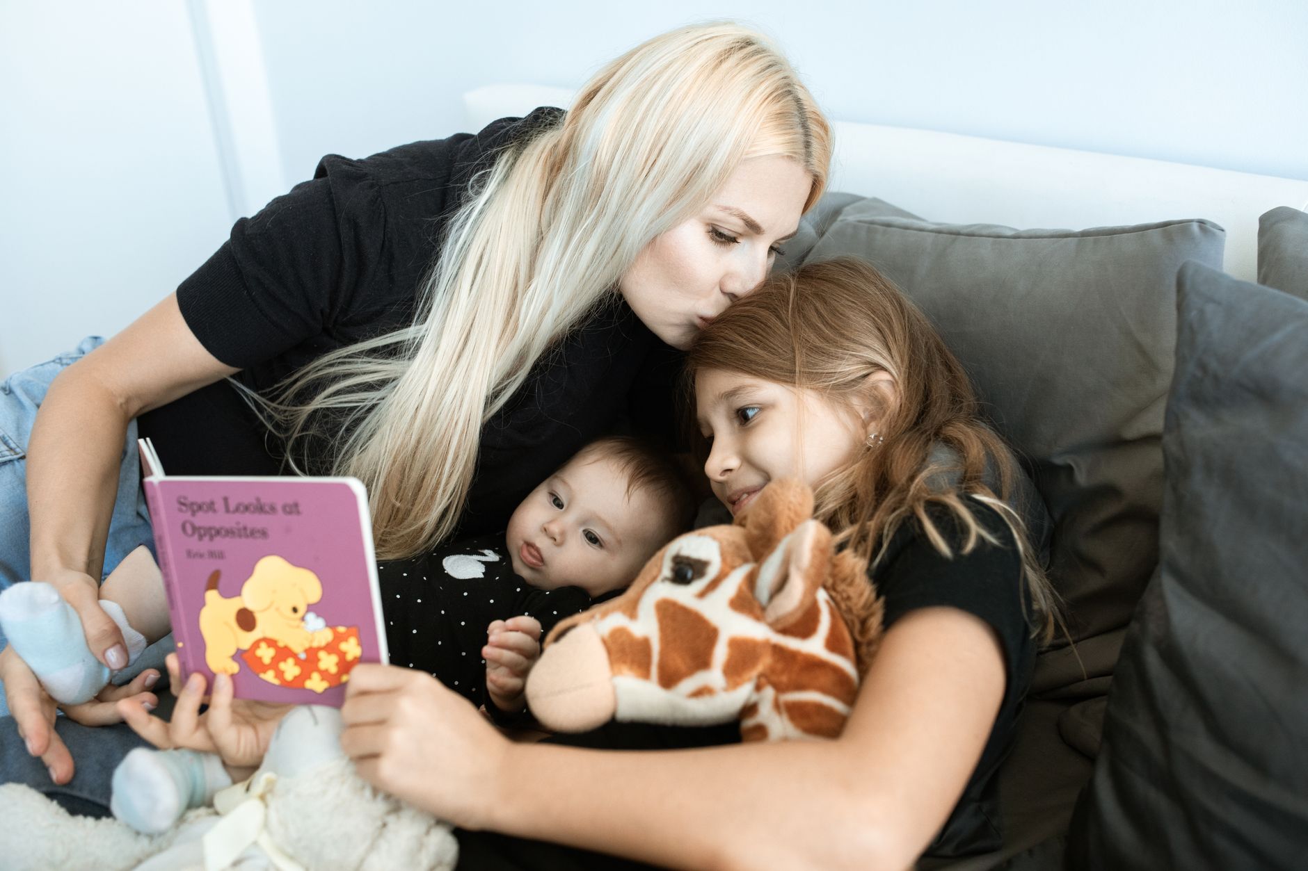 Mother and baby reading a colorful board book, illustrating early language development.