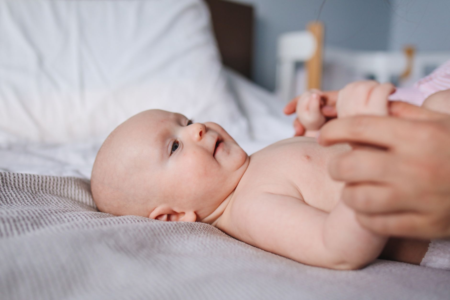 Newborn baby being held skin-to-skin by a parent, with a nurse monitoring their breathing