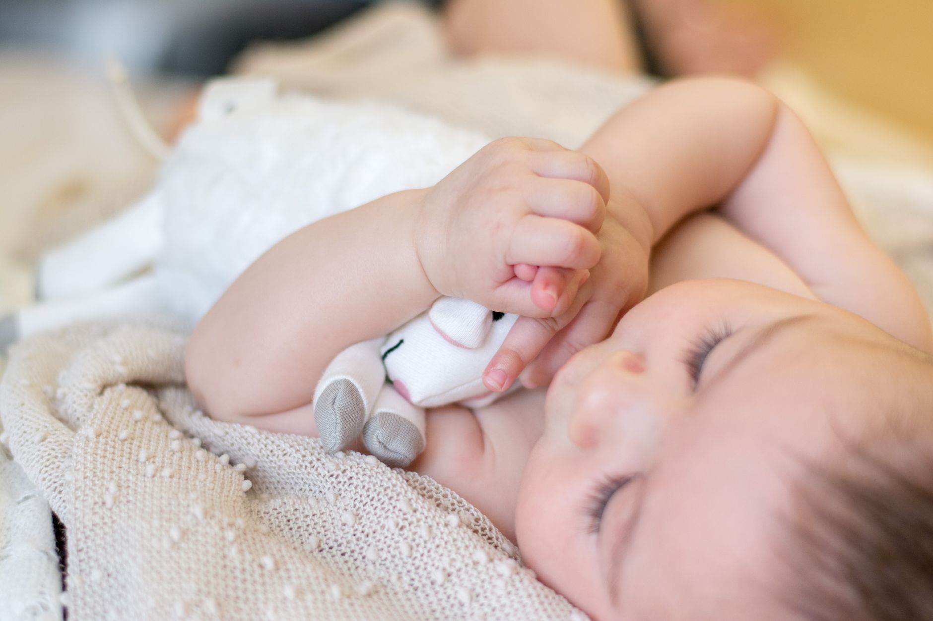 Parent giving plush toy to baby
