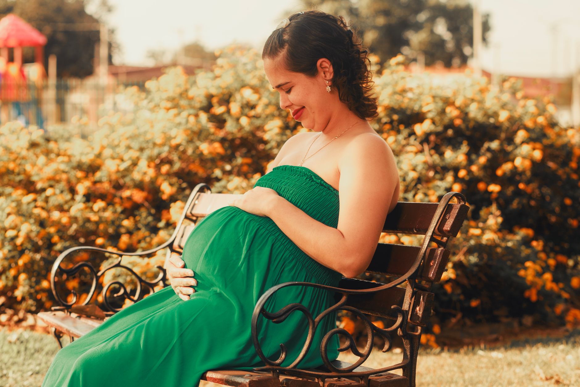 Pregnant woman walking in a park during spring