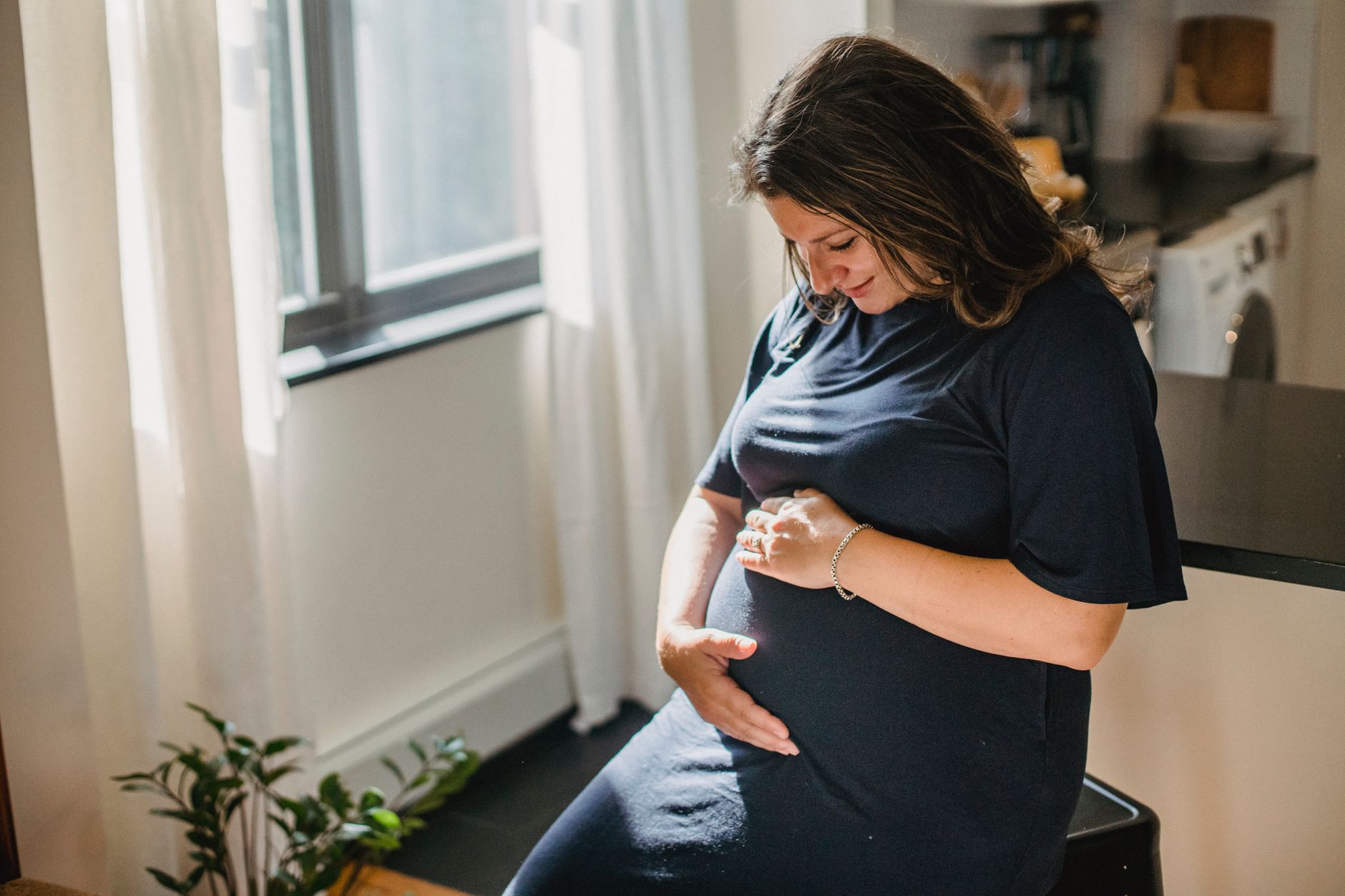 Pregnant woman sitting and feeling kicks