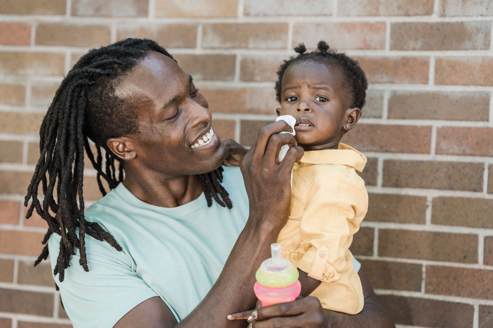 Parent using nasal aspirator on baby
