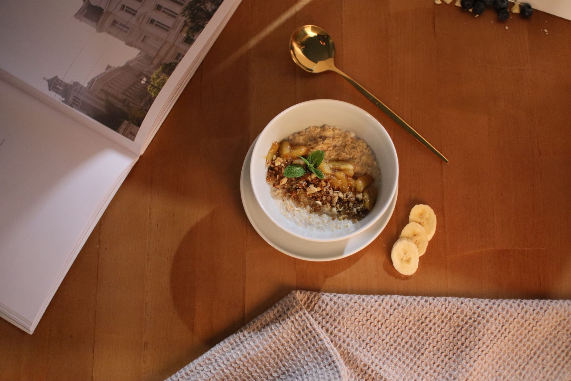 A bowl of plain oatmeal topped with a drizzle of honey and sliced banana, suitable for a toddler with sore mouth