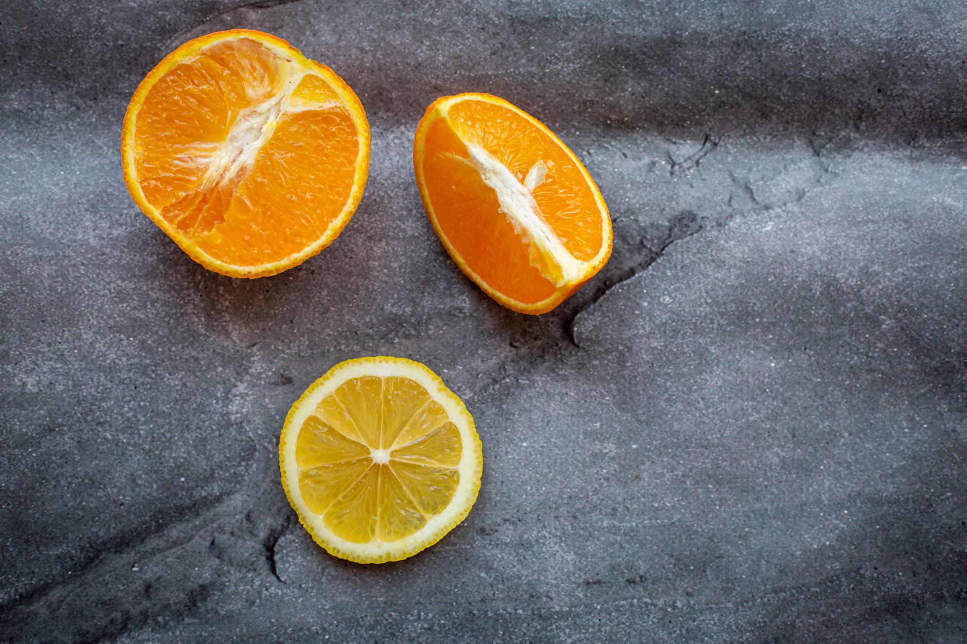 Freshly sliced citrus fruits and leafy greens arranged on a wooden board, bright daylight highlighting vibrant colors