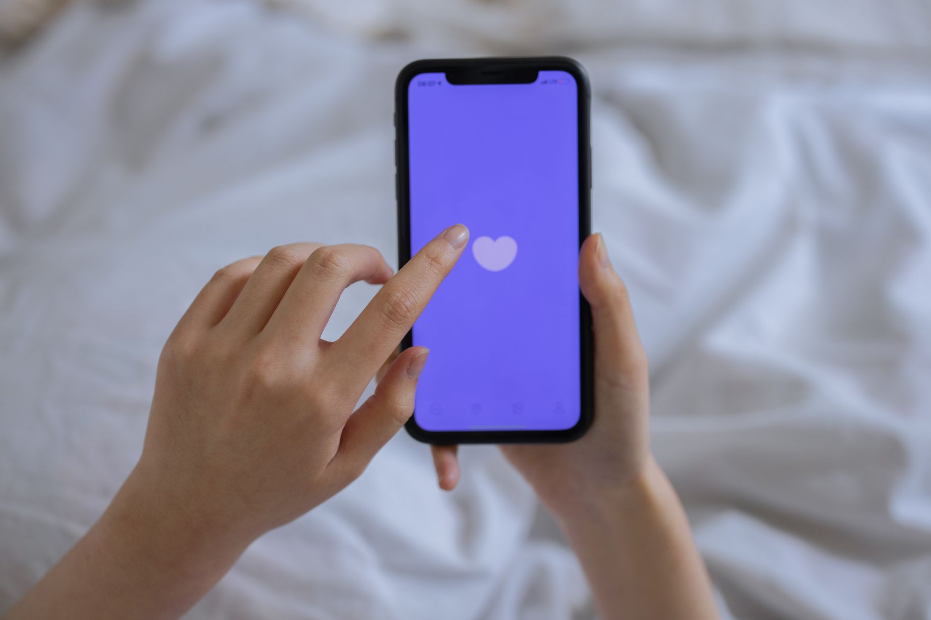 Close‑up of a smartphone screen displaying a simple questionnaire about parity, gestational age, and labor onset, bright indoor lighting, hand holding device, modern UI