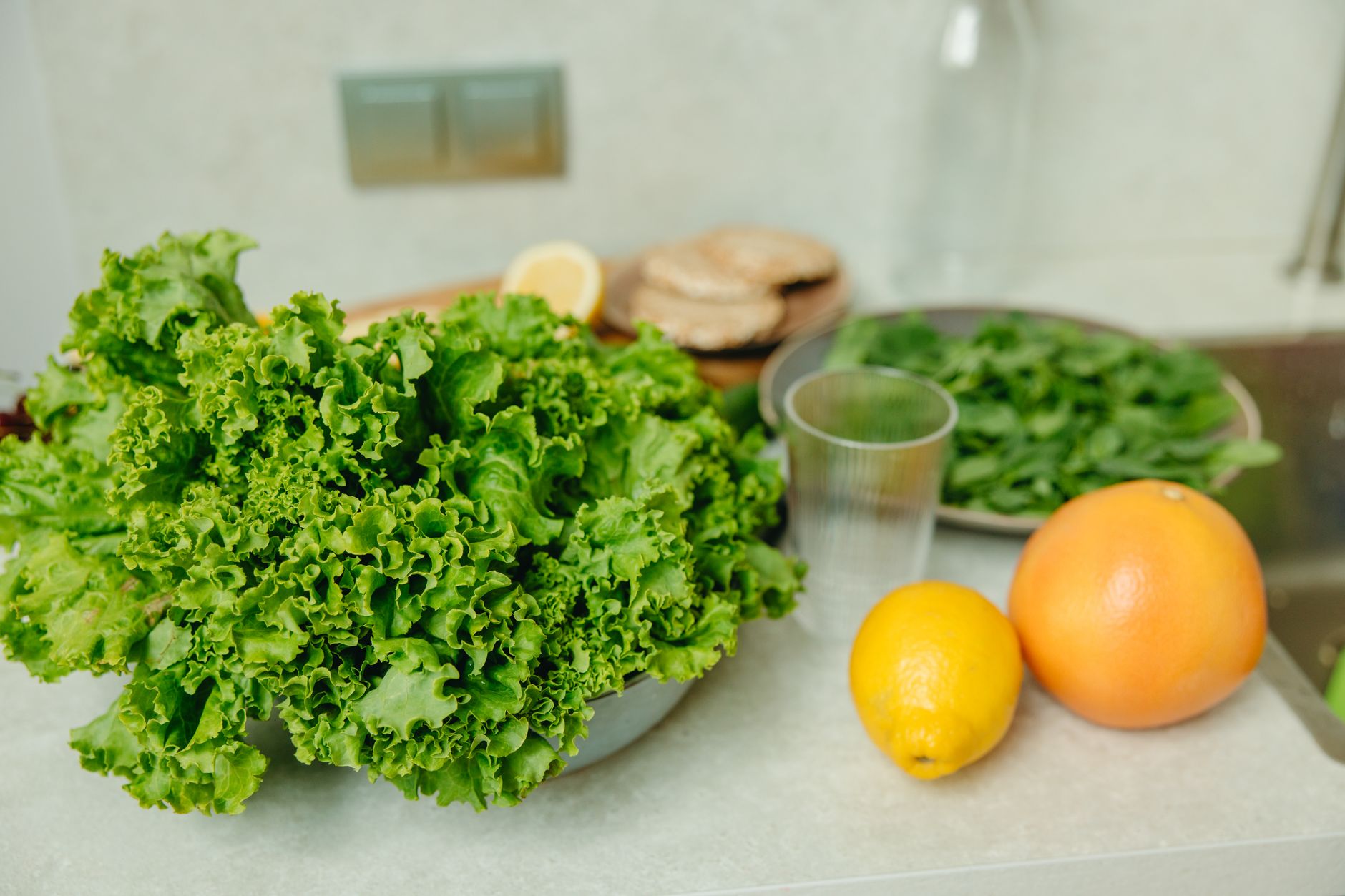 A serene kitchen counter displaying a glass of orange juice, a bowl of iron‑rich spinach salad, and a prenatal vitamin bottle, illustrating healthy post‑donation nutrition for pregnant donors