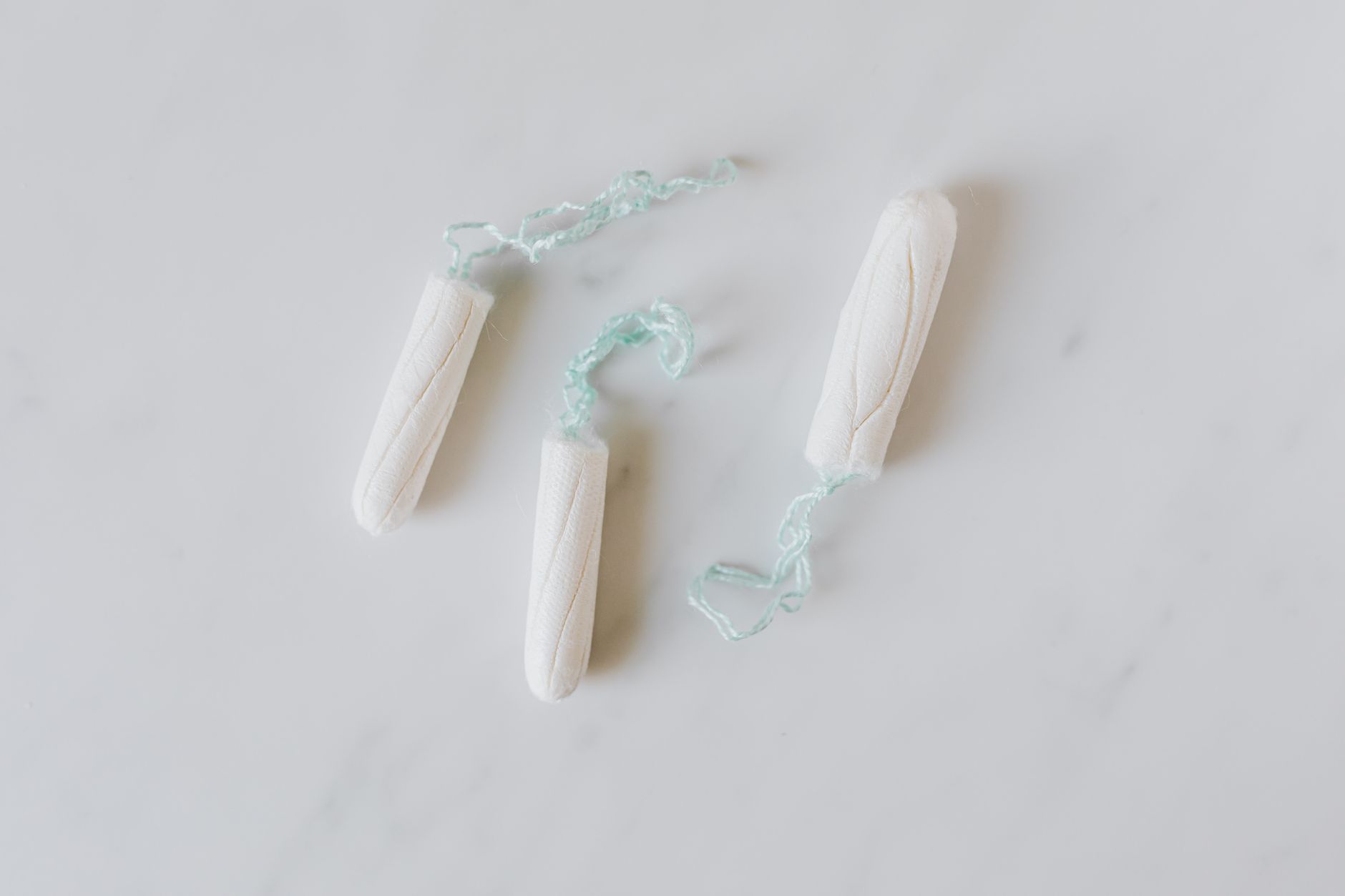 Close-up of a hand holding an IUD device with visible strings