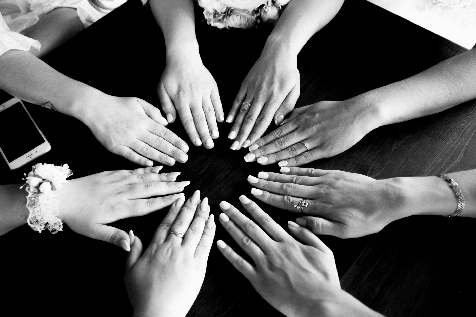 A diverse group of women sitting in a circle, holding hands, representing support and community