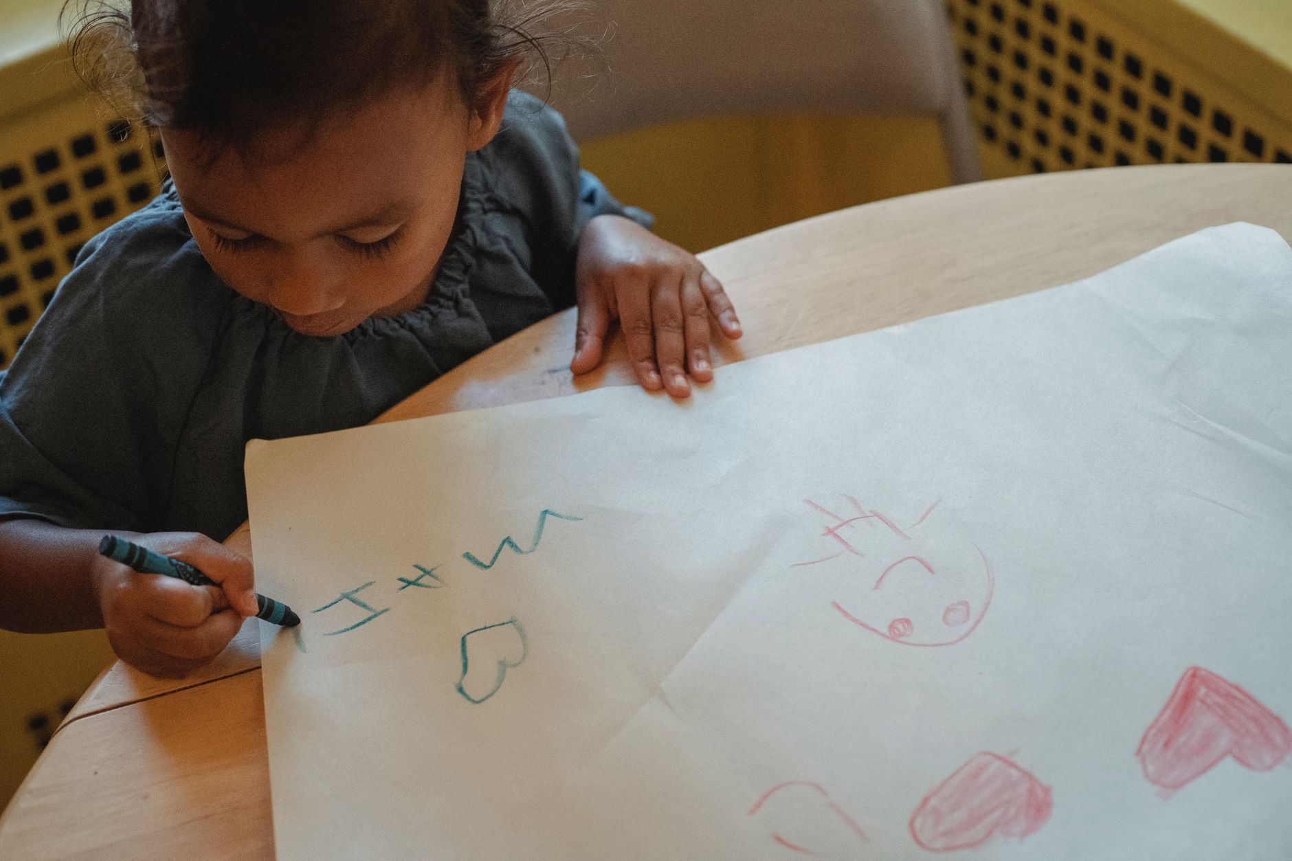 Toddler coloring a bus while listening to Cocomelon.