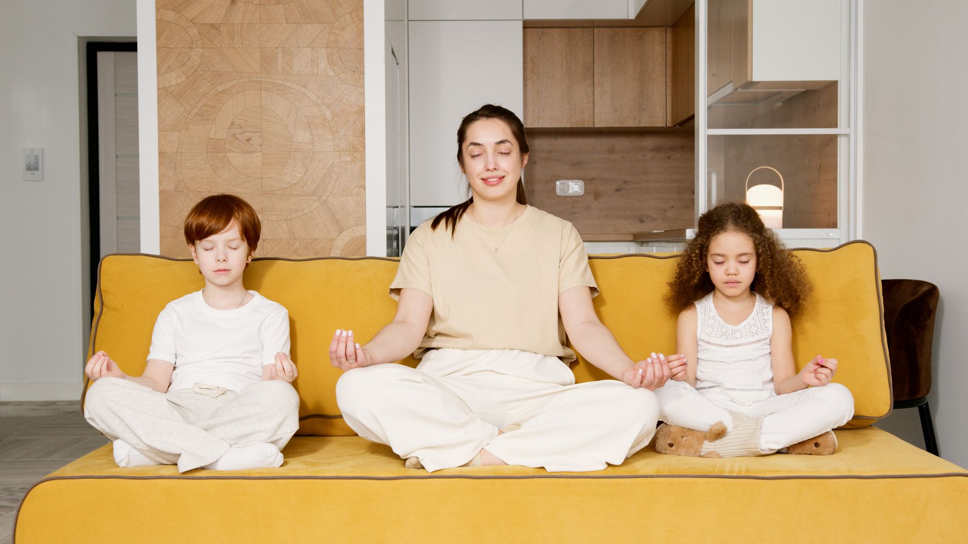 A serene woman meditating, with children playing in the background, symbolizing peace amidst parenting.