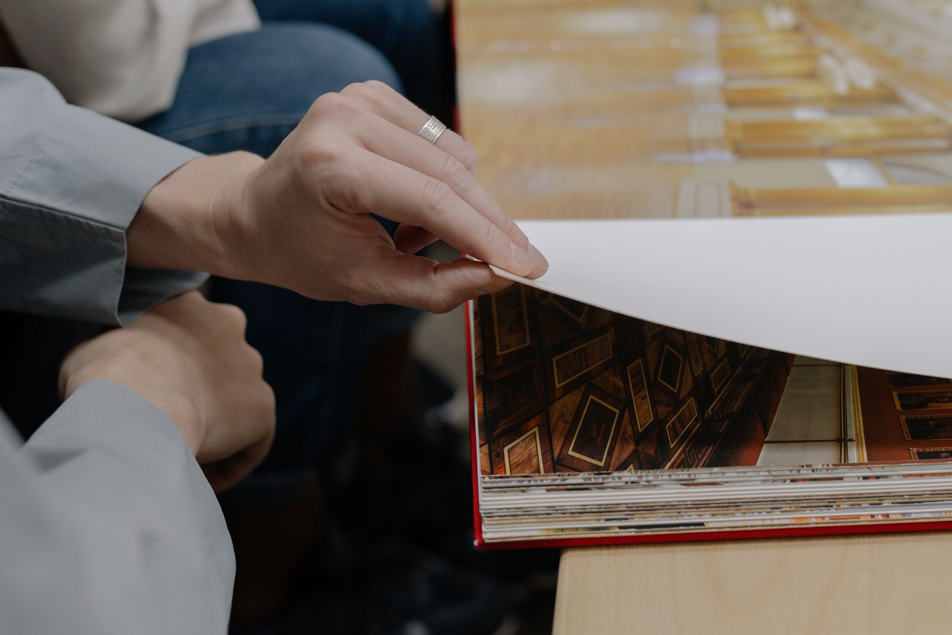 A nostalgic photo album opened to a page with baby shoes beside a vintage family portrait, soft natural lighting on a wooden table