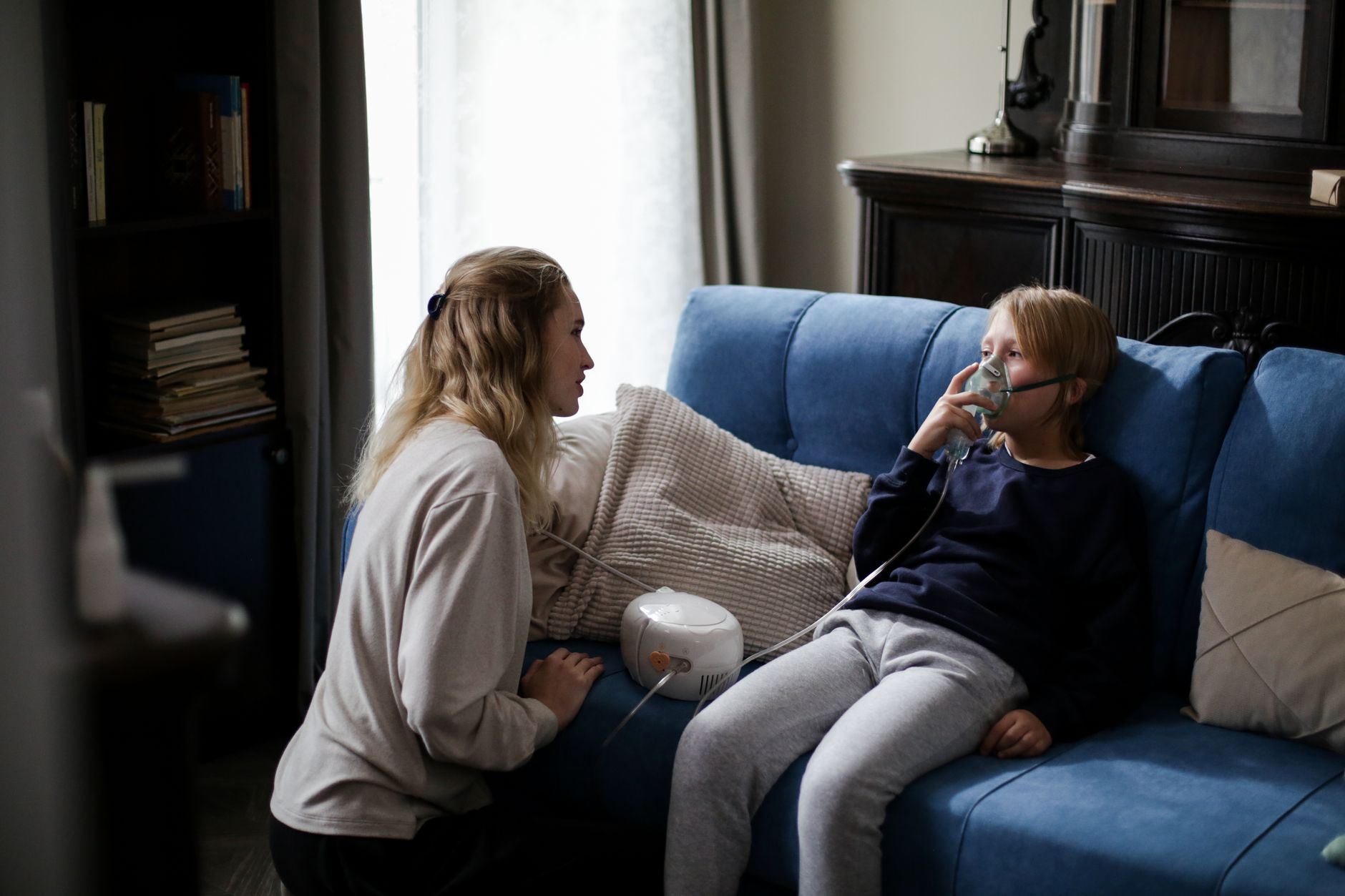 A child using a nebulizer with a parent nearby, illustrating home treatment for respiratory issues