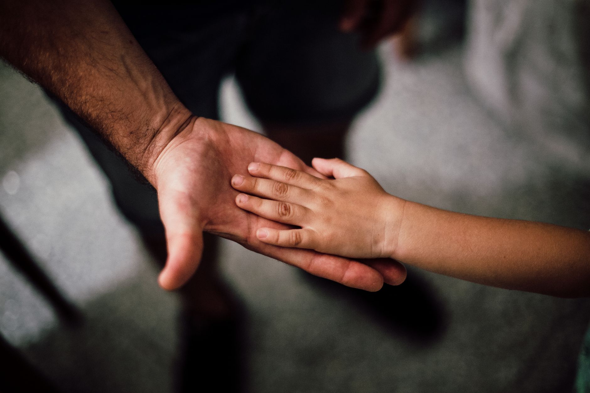 Dad holding hands with his older child in the hospital waiting room