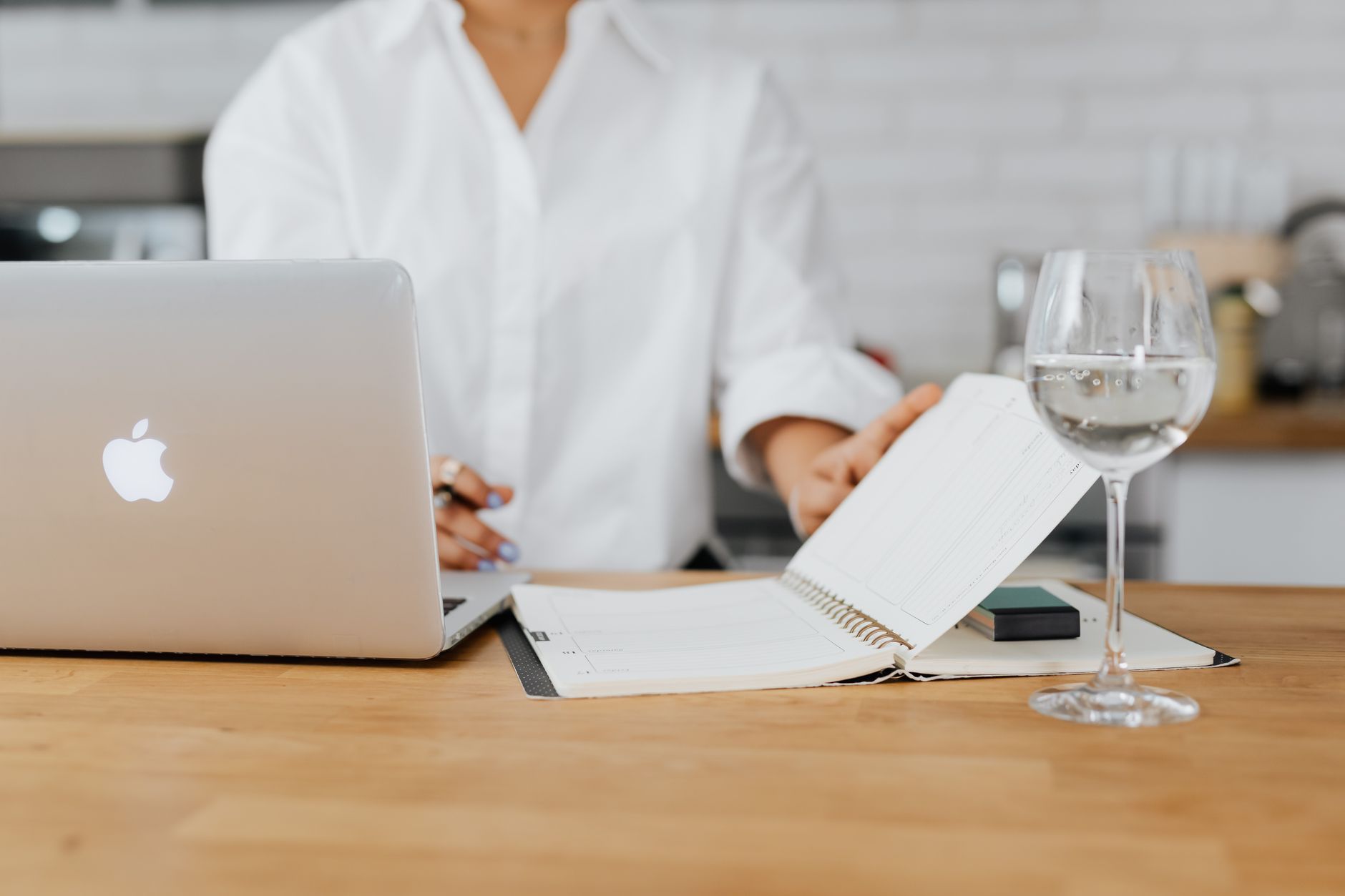A mom sitting at a desk with a digital planner showing breastfeeding schedule tracking.