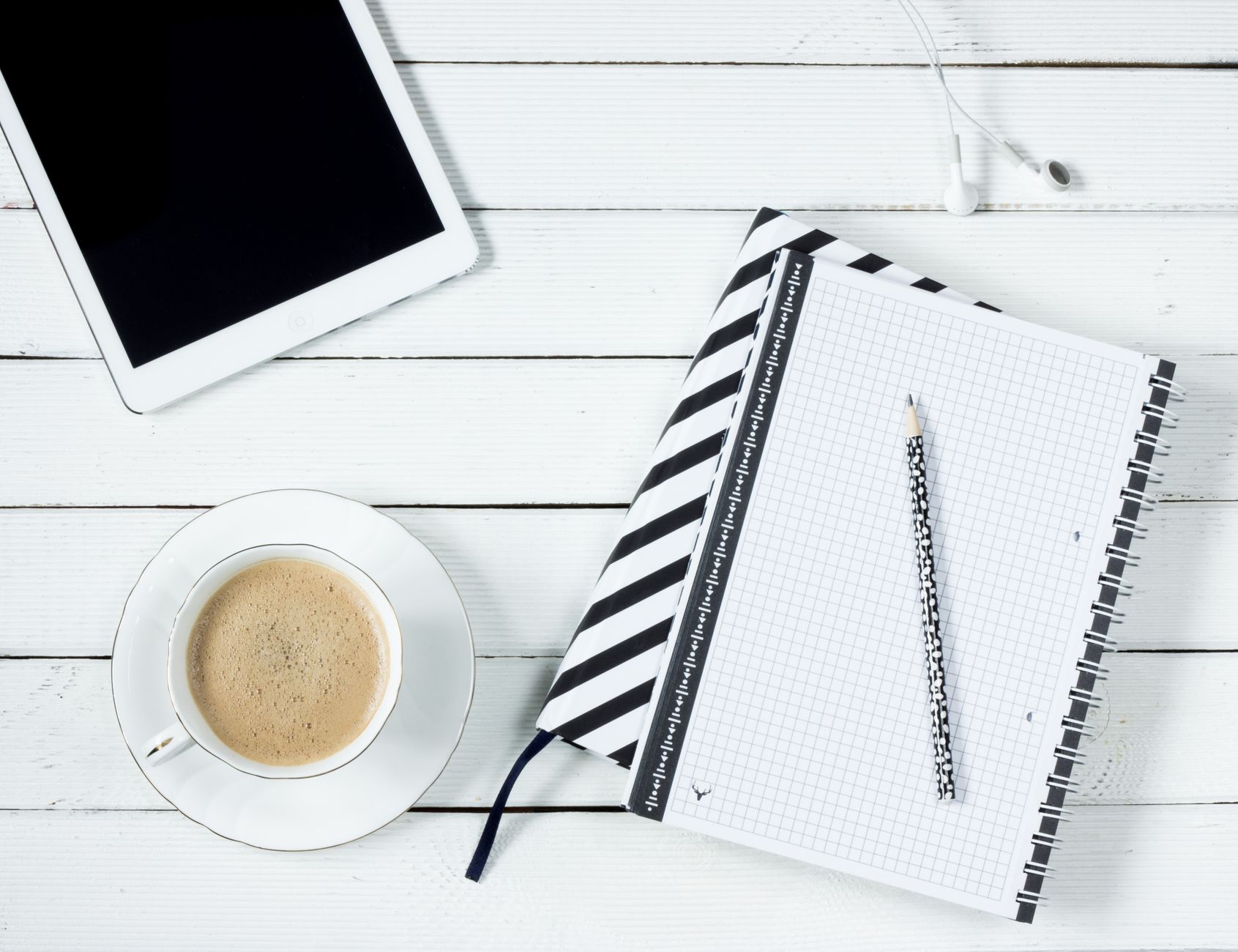 A split image showing a mom using a digital planner on her tablet and a mom writing in a paper planner.