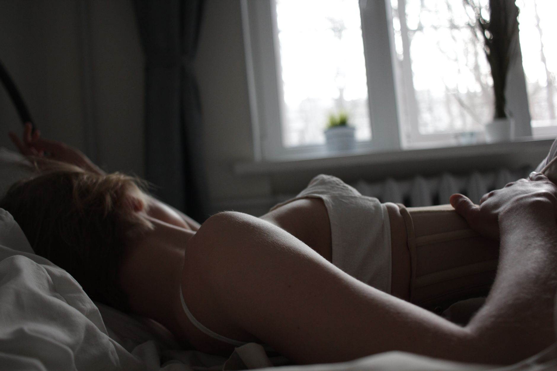 A woman's hand gently touching her lower abdomen, soft lighting, indicating mild cramping or discomfort