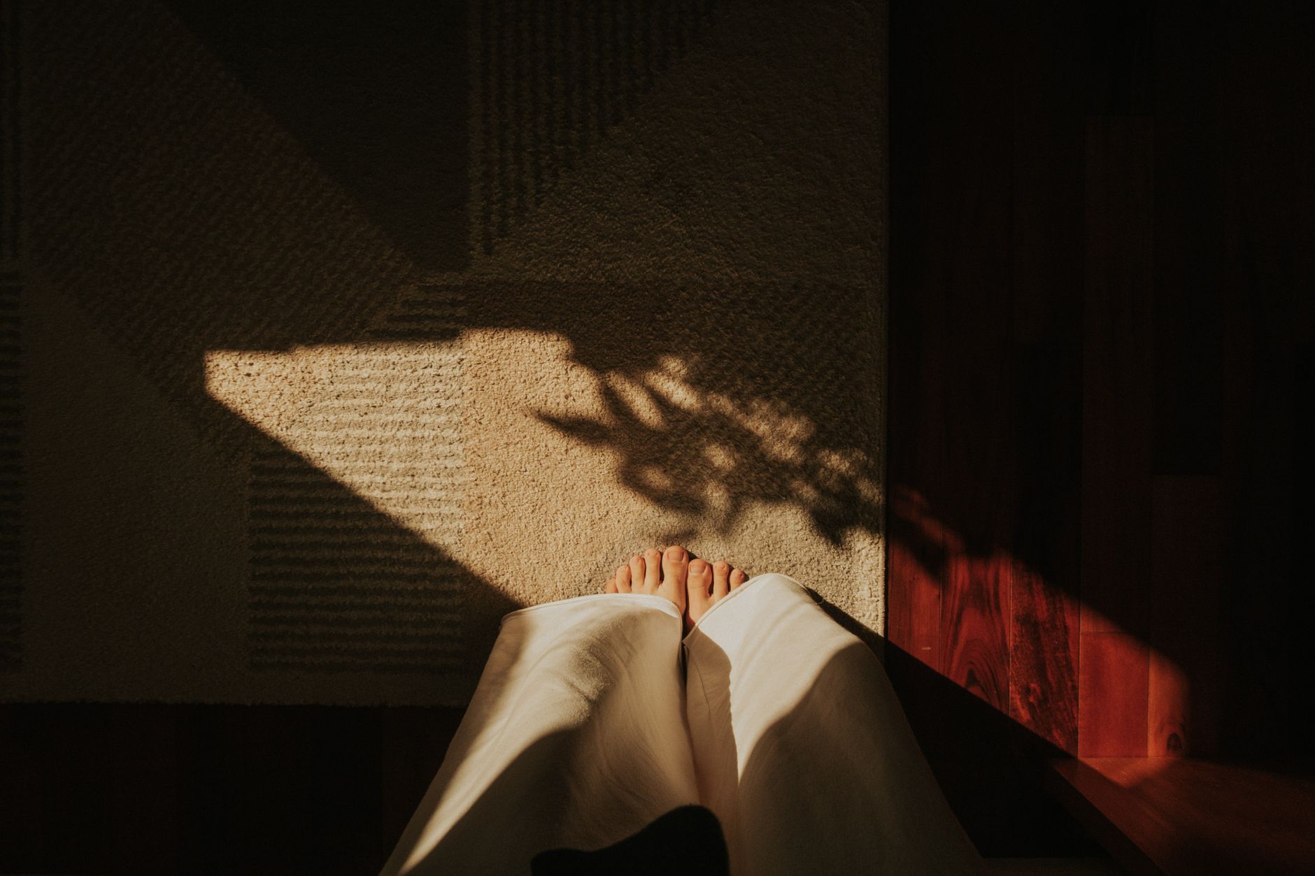 Pregnant‑postpartum woman doing gentle yoga on a mat with a soft sunrise light, showing relaxed posture and calm atmosphere