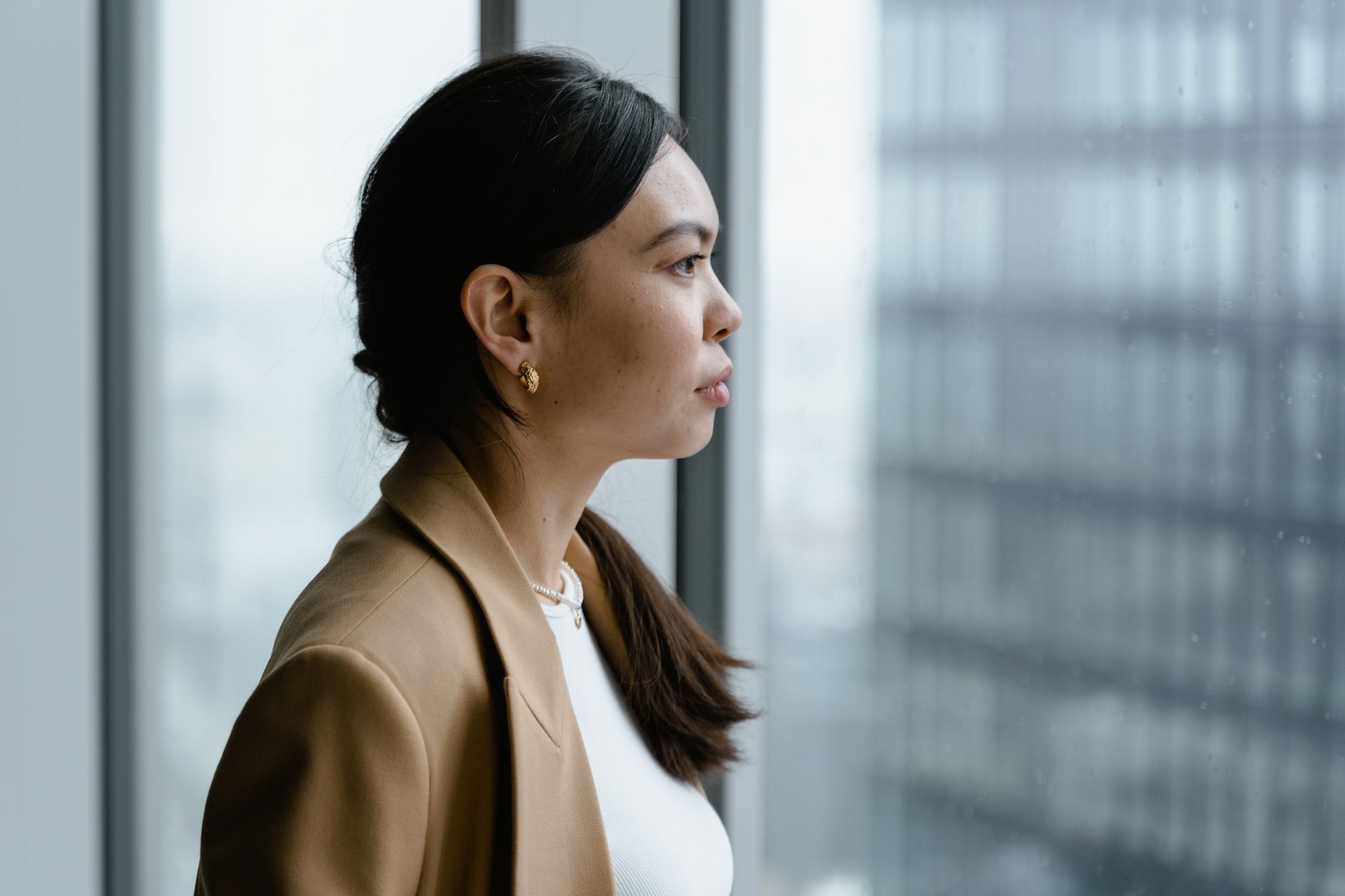 A woman in her early thirties looking thoughtful, symbolizing contemplation of future family planning and fertility decisions.