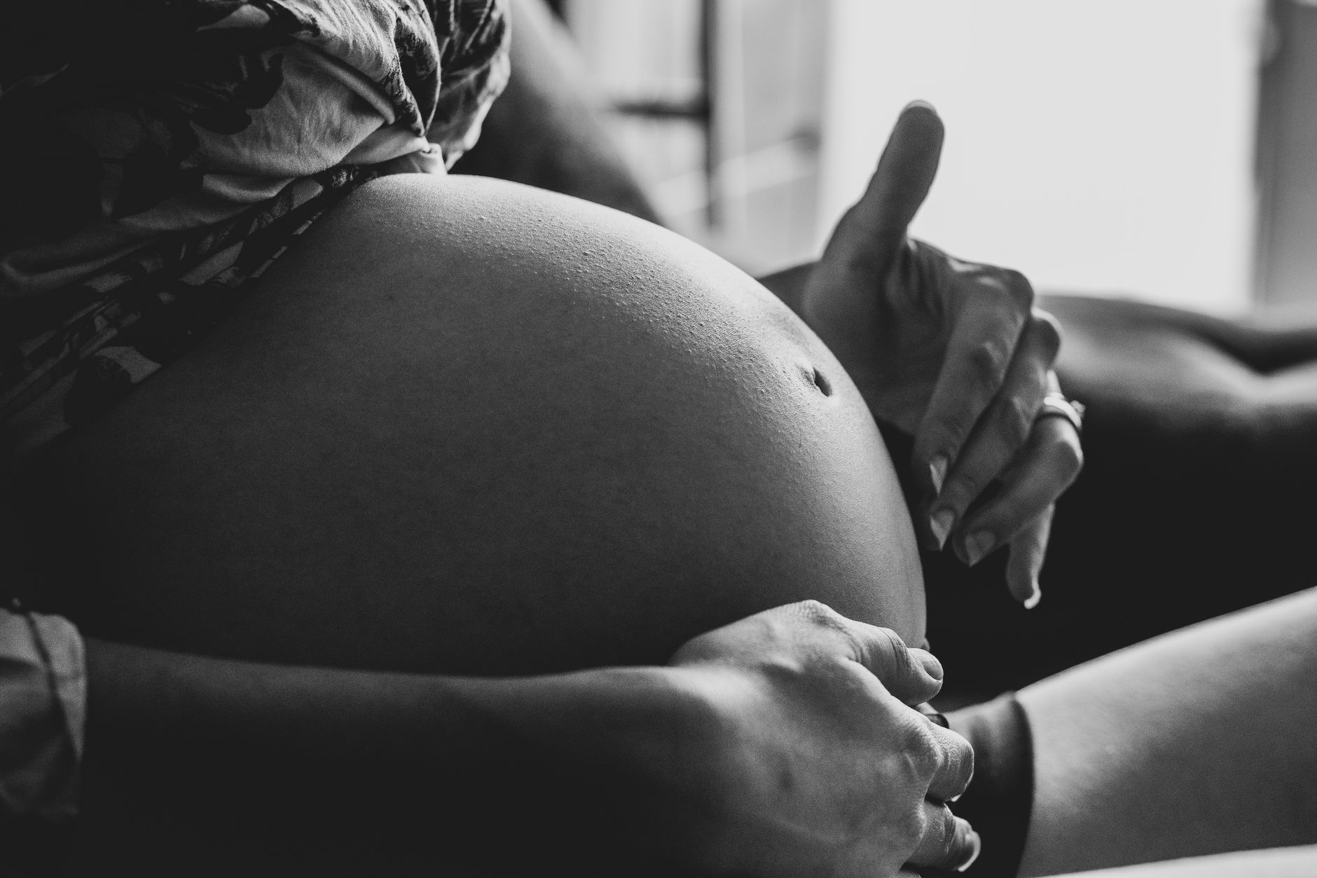 Woman performing a self‑check for baby head engagement