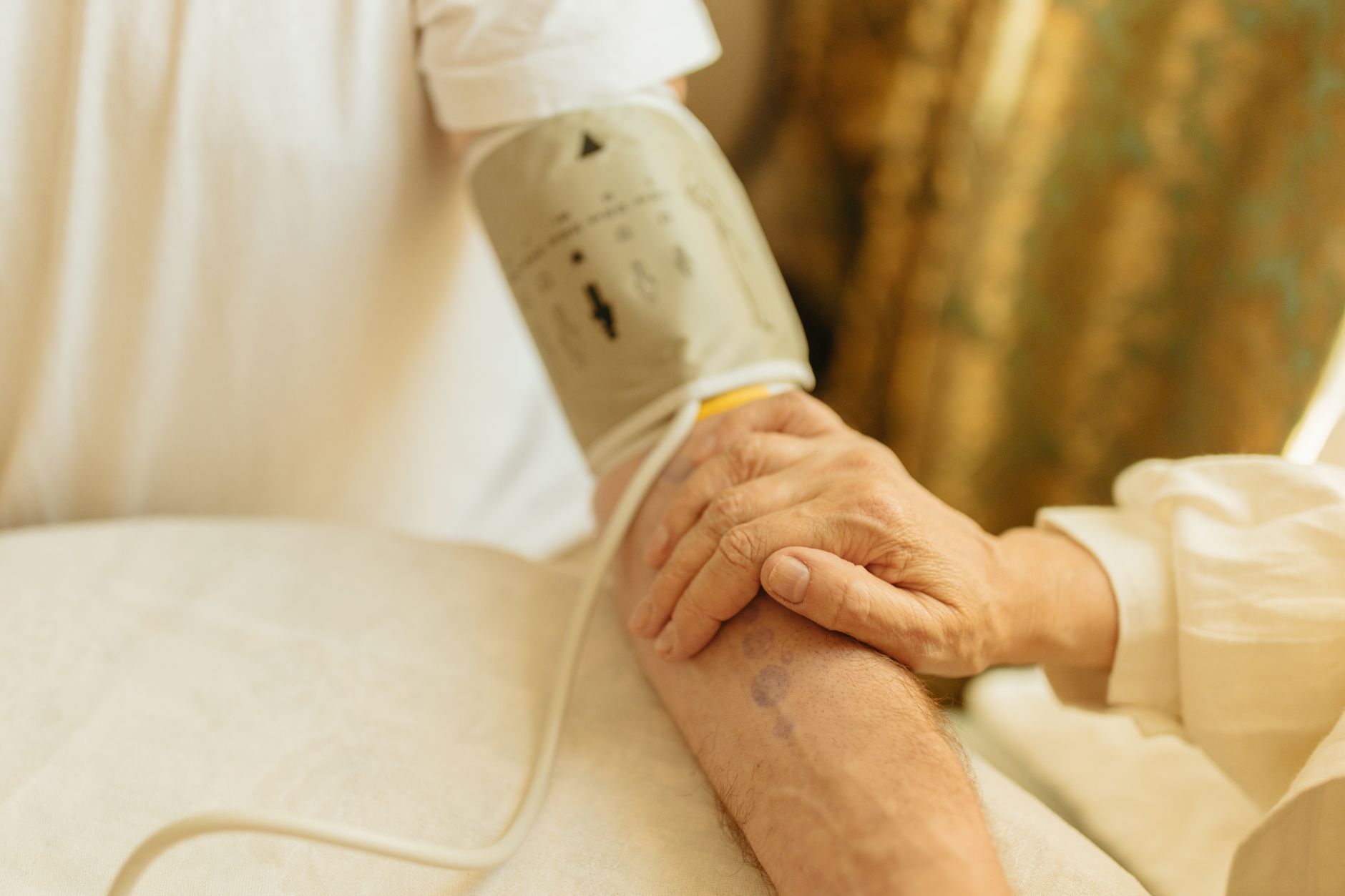 Close‑up of a fetal heart rate monitor screen showing a Category II tracing with occasional variable decelerations, soft hospital lighting, and a hand gently adjusting the mother’s position