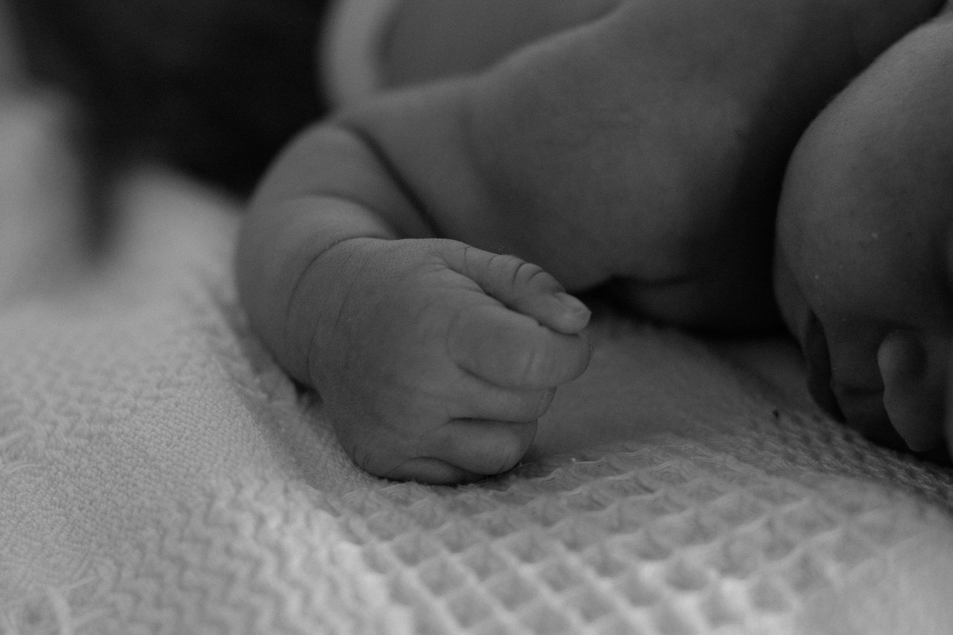 Cozy newborn care area with a soft blanket, a bottle, and a sleep monitor, highlighting the Eat Sleep Console approach, warm natural lighting