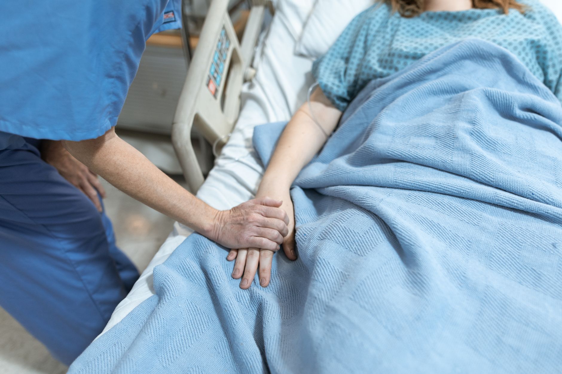 A calm mother-to-be in a hospital room with her partner, focusing on breathing.